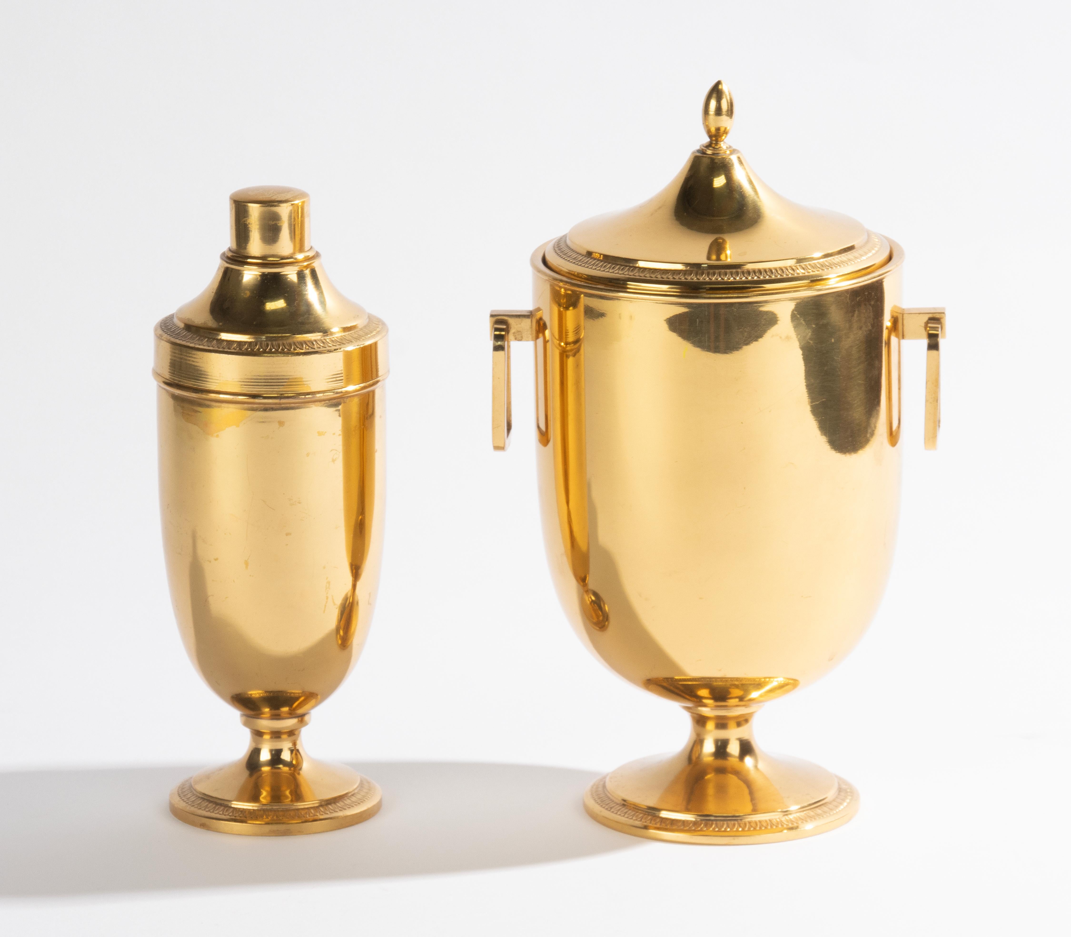 Un bonito conjunto de artículos de bar vintage, una cubitera y una coctelera. Fabricado por el fabricante italiano Macabo, diseñado por Aldo Tura. De metal dorado.
Estilo Regencia de Hollywood, hacia 1960. La coctelera está marcada en la parte