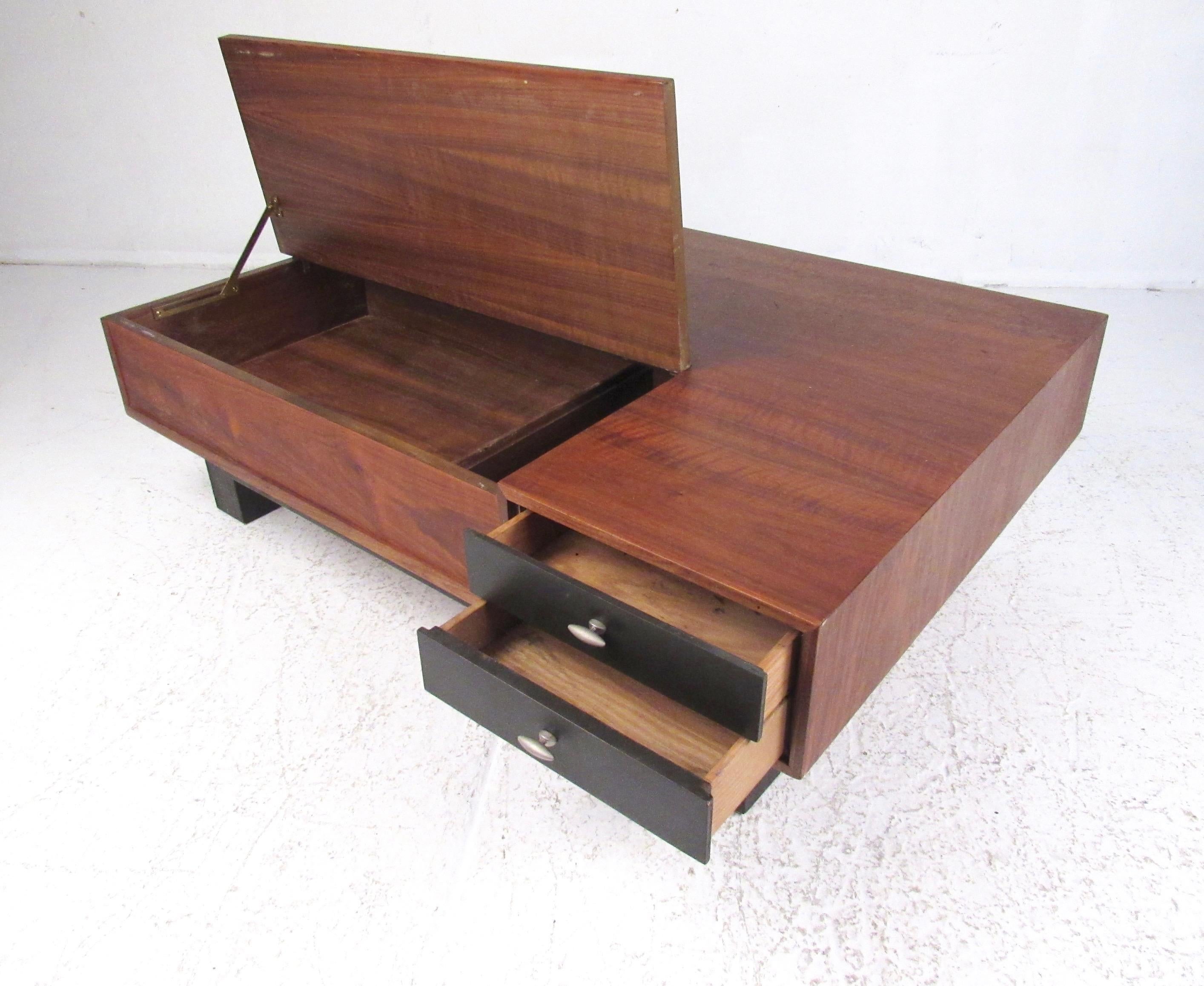 This impressive vintage modern coffee table by Drexel furniture features beautiful walnut finish, ebonized hardwood sides, and unique drawer pulls. Two in one storage options include a pair of matching drawers and a lift top interior cabinet,