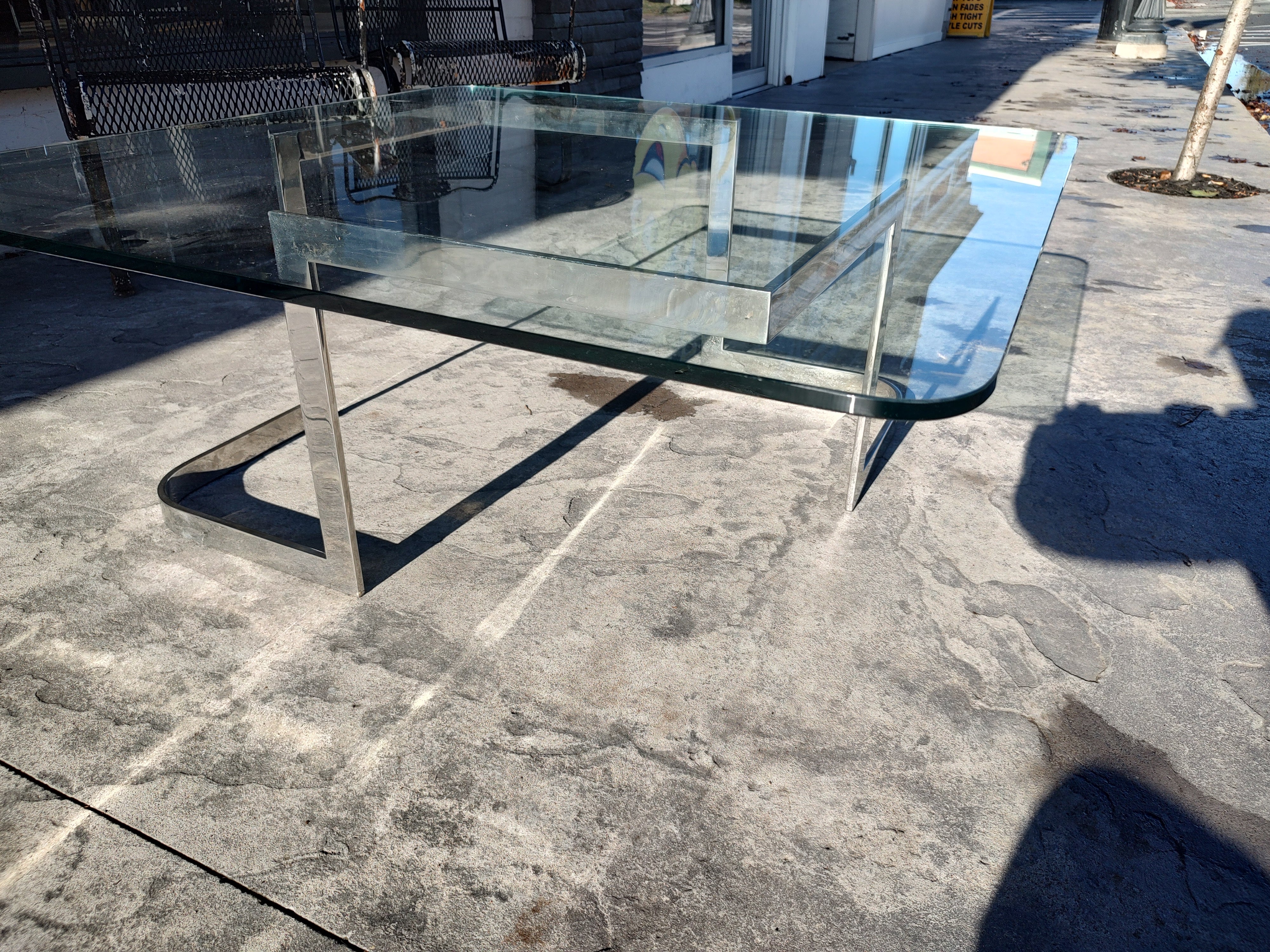 Fabulous and rare piece. Straight from the Dakota apartment building in NYC. 41.5 square glass top with a curved and straight edge chrome Base. #6703 by Kagan. In excellent vintage condition with minimal wear.