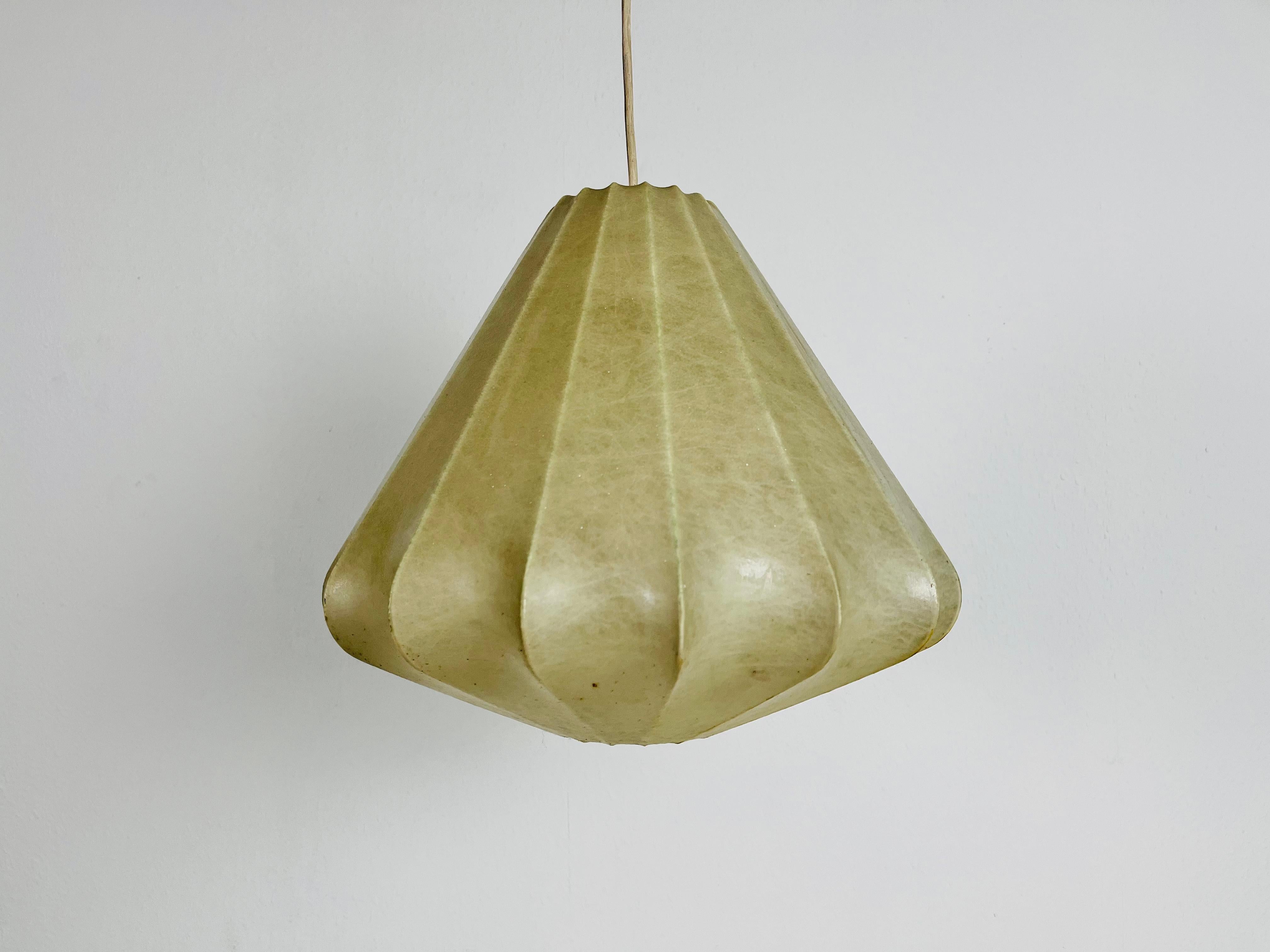 Eine Kokon-Pendelleuchte, die in den 1960er Jahren in Italien hergestellt wurde. Die Hängelampe wurde im Design der Lampen von Achille Castiglioni hergestellt. Der Lampenschirm ist aus originalem Kokon und hat eine organische Form. 

Maße: