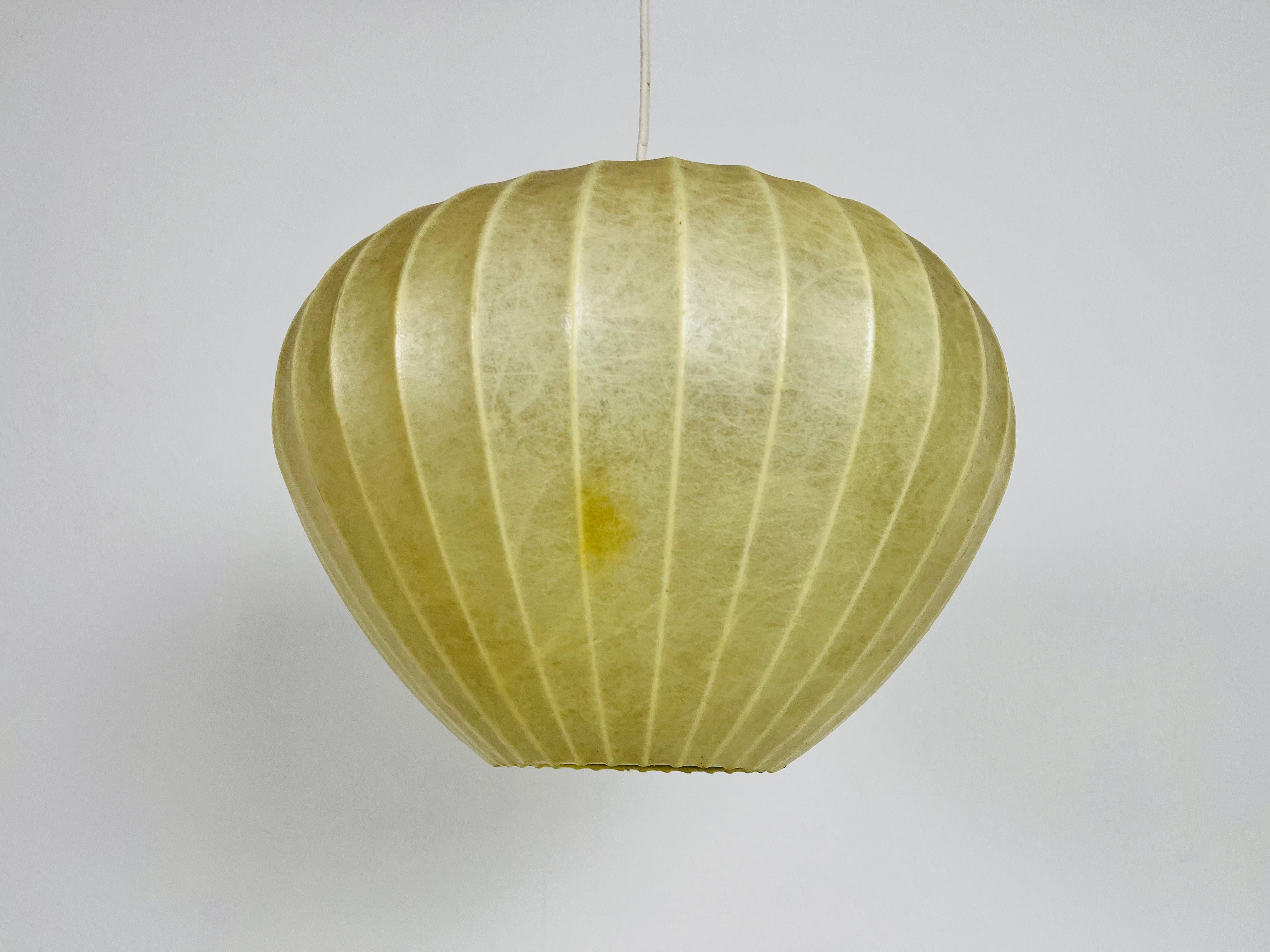 A cocoon pendant lamp made in Italy in the 1960s. The hanging lamp has been manufactured in the design of the lamps made by Achille Castiglioni. The lamp shade is of original cocoon and has an organic shape. 

Measures: Max height: 24-100