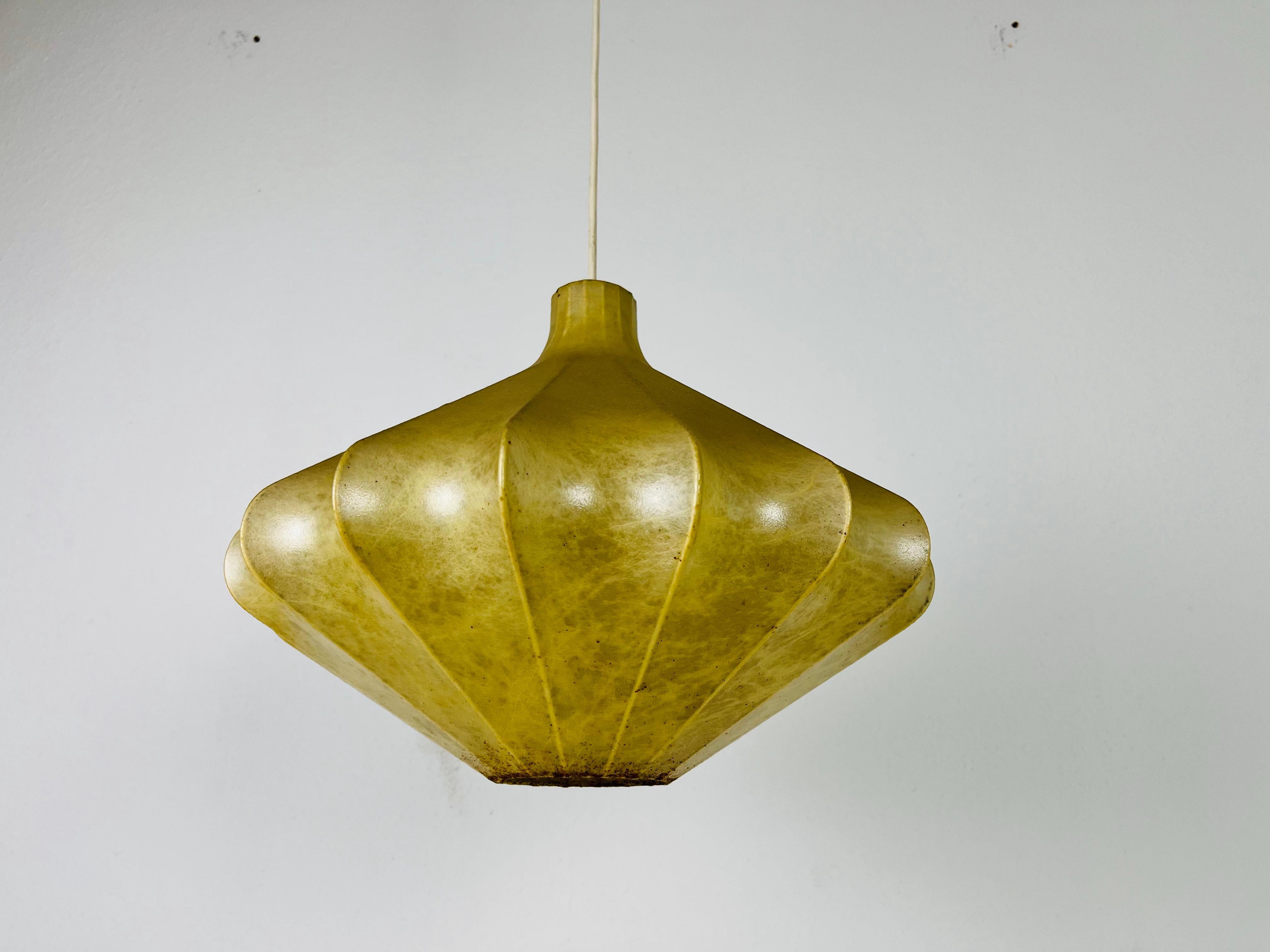 A cocoon pendant lamp made in Italy in the 1960s. The hanging lamp has been manufactured in the design of the lamps made by Achille Castiglioni. The lamp shade is of original cocoon and has an organic shape. 

Measures: 
Height: 30-80
