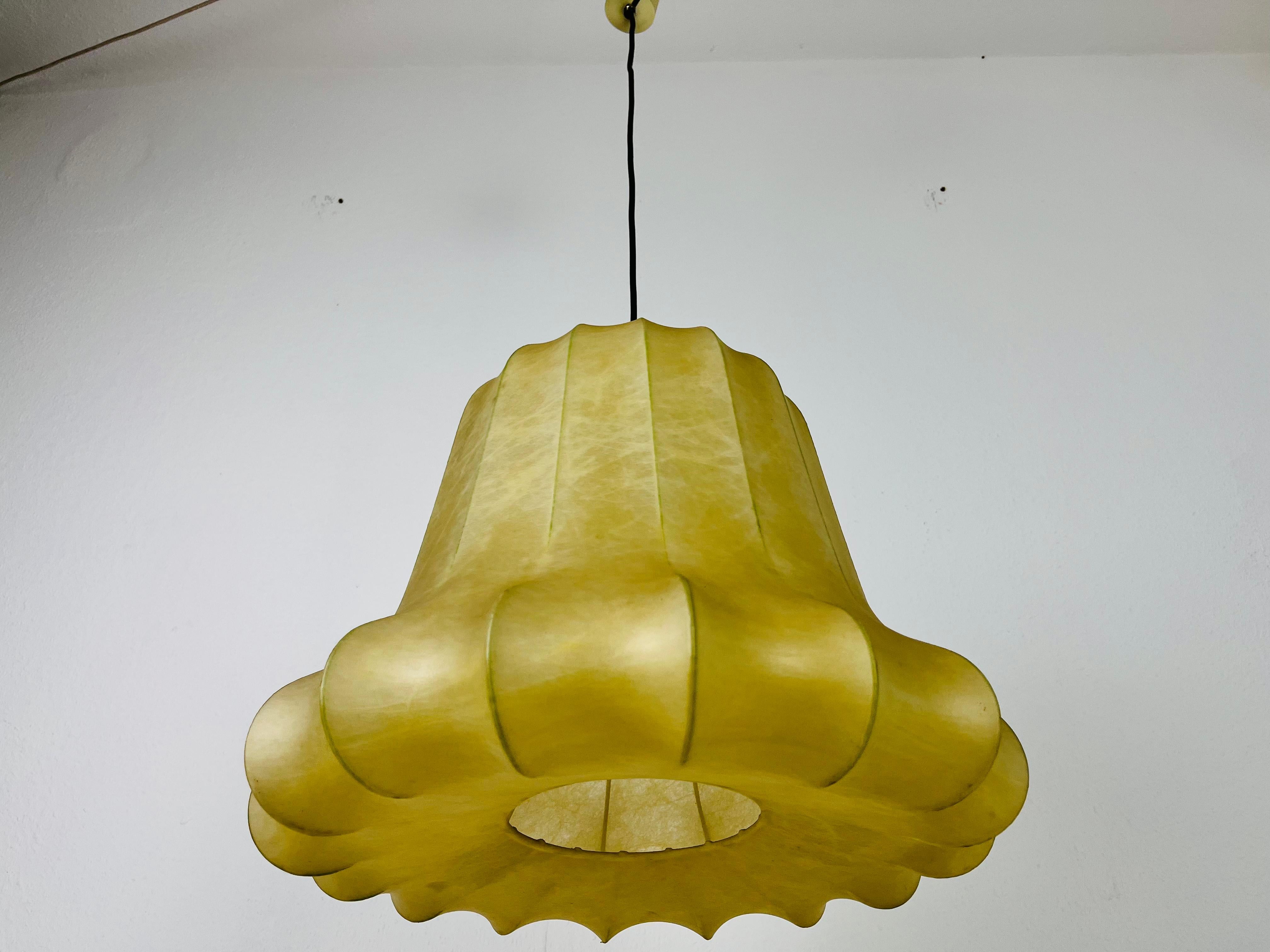 A cocoon pendant lamp made in Italy in the 1960s. The hanging lamp has been manufactured in the design of the lamps made by Achille Castiglioni. The lamp shade is of original cocoon and has an organic shape. 

Measures: 
Height: 35-95 cm
Diameter: