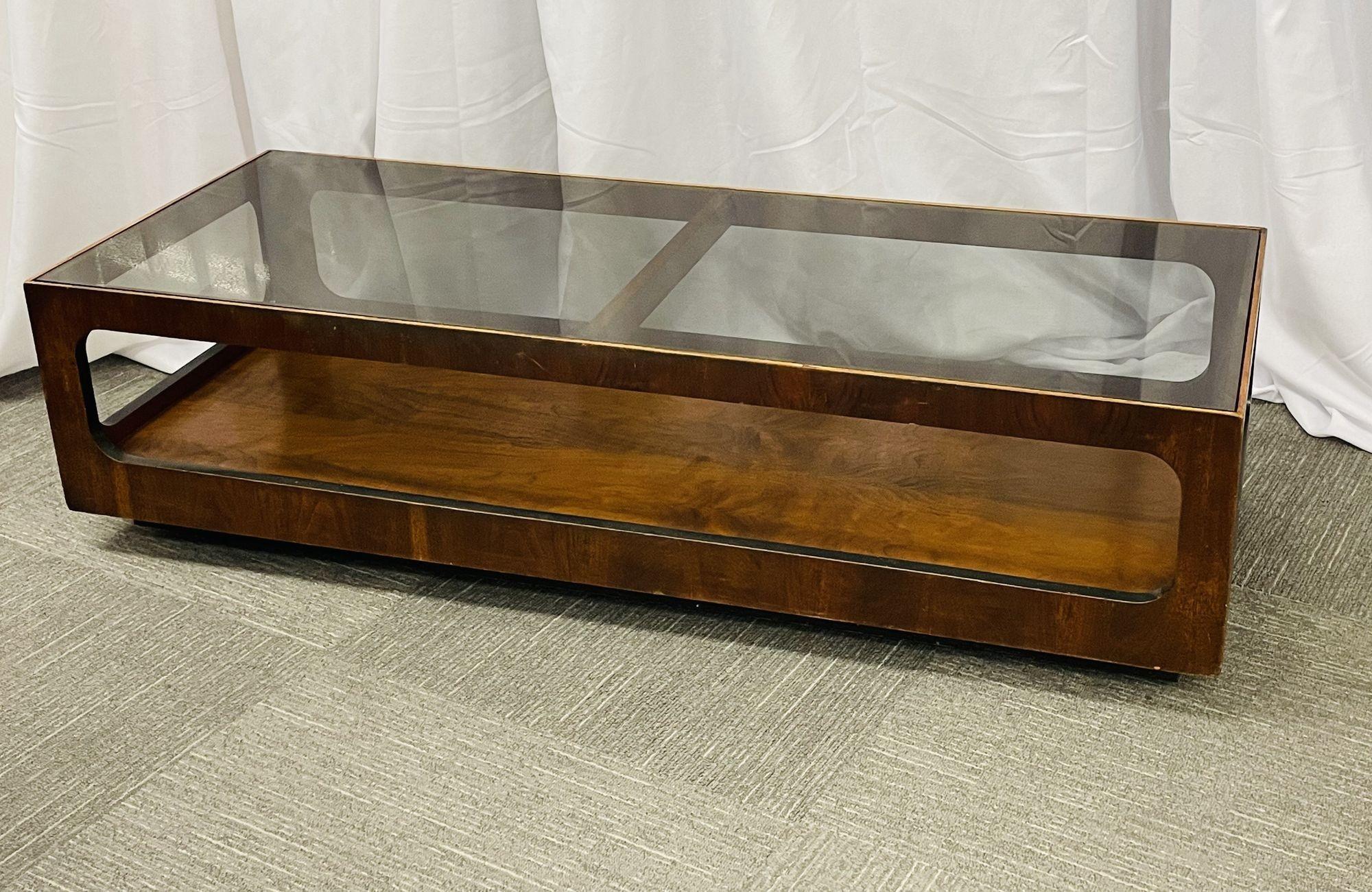 A Mid-Century Modern sculptured coffee table of walnut and ebony decorated design with a smoked glass top by Lane. In casters.
 
20.75 by 55 long by 14 H.