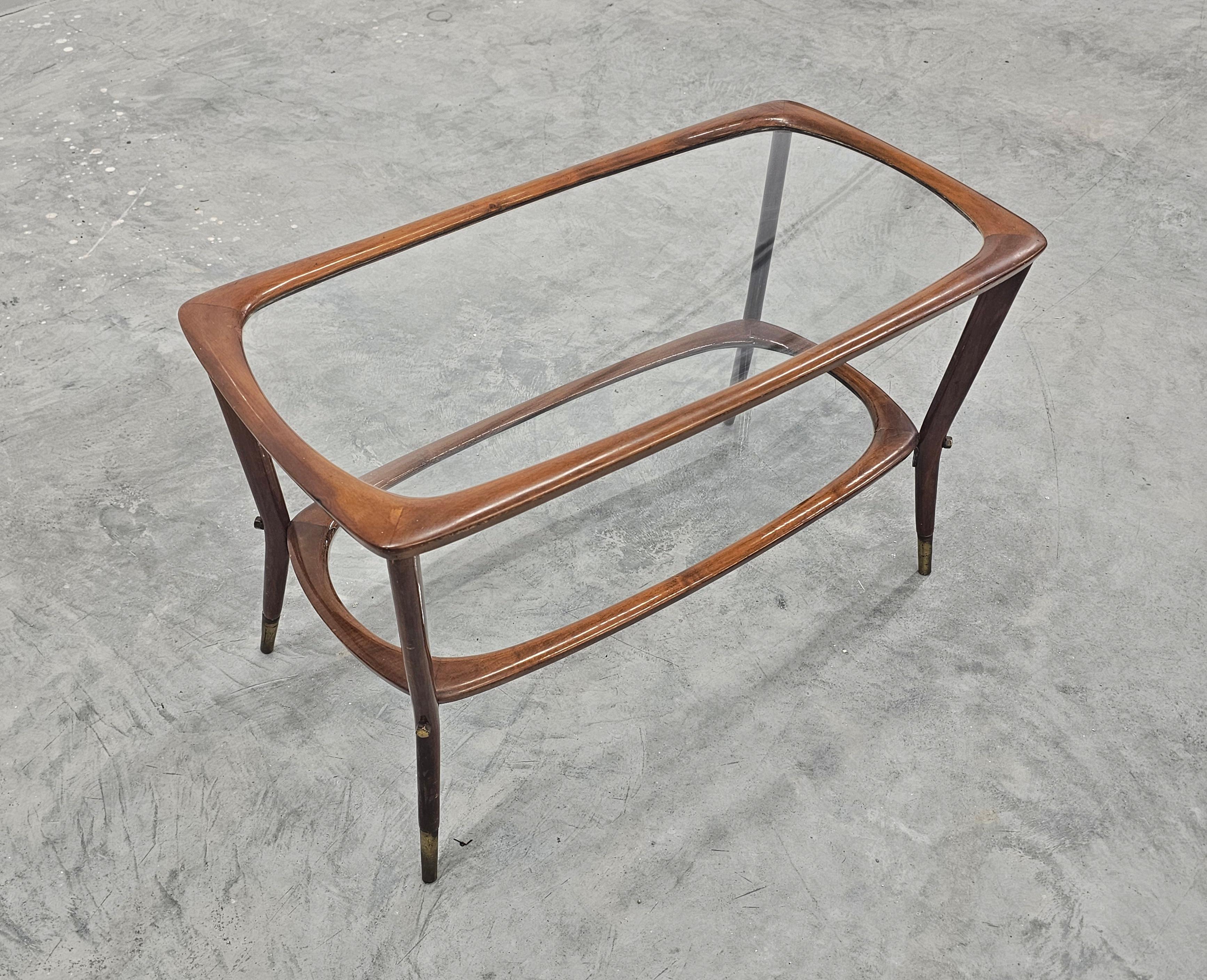 In questa inserzione troverai uno degli iconici design del maestro italiano Cesare Lacca. Il tavolino da caffè o tavolino a 2 livelli è caratterizzato da linee belle ed eleganti con la sua struttura in noce e i piani in vetro trasparente. Realizzato