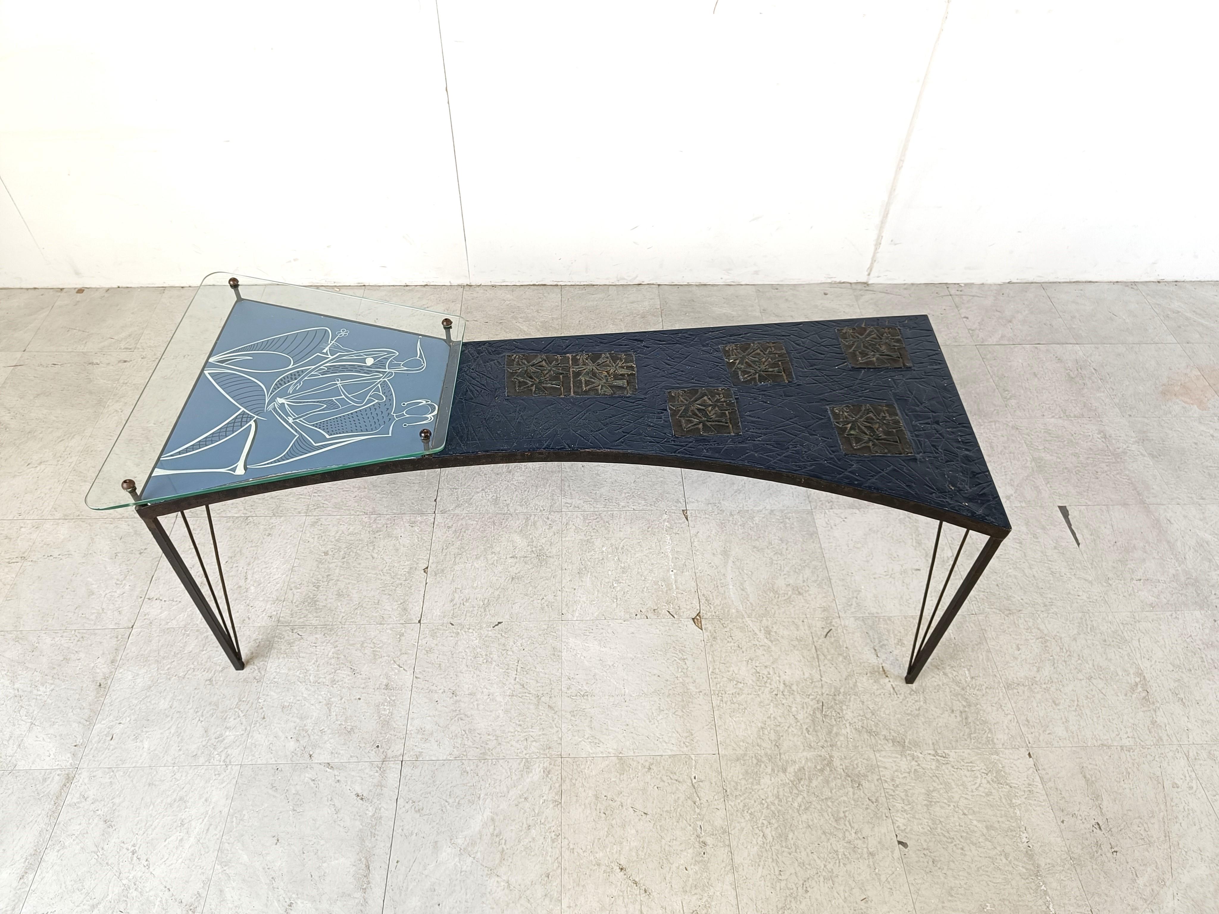 Vintage sculptural coffee table consisting of 4 black metal legs, a sculpted resin table top, a wooden panel with a minimalist artwork and a glass shelf.

Very unique mid century coffee table by unknown artist.

1950s - France

Good