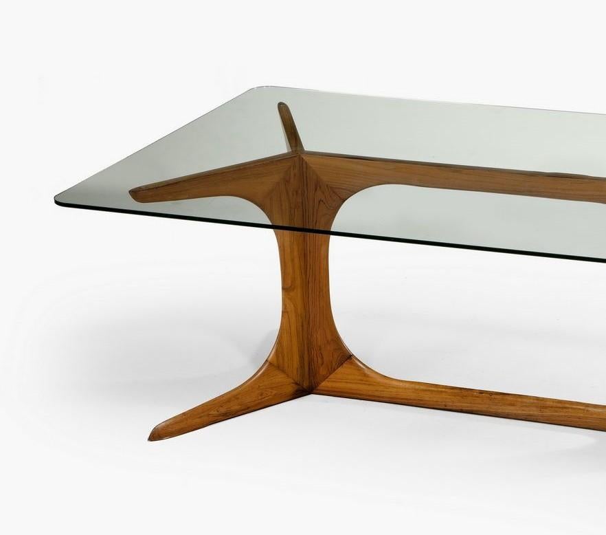 Fine quality coffee table attributed to Guglielmo Ulrich. The table has a strong base beautifully cut and crafted which has an elegant sculptural quality. It is simple and chic. The wood is beautifully polished to make an elegant table. The glass