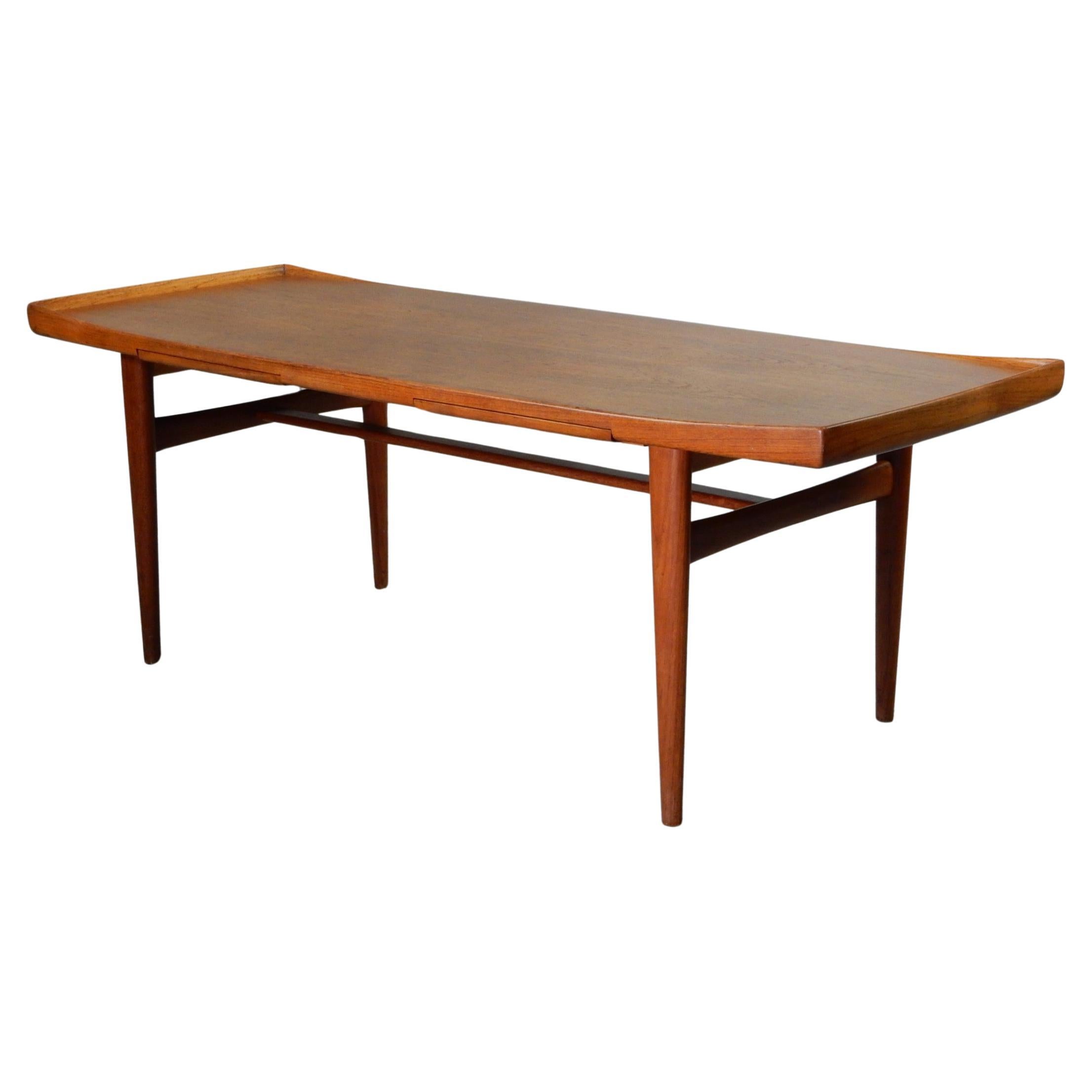 Swedish mid century teak coffee table by designer Alf Svensson, circa 1960s. This table features 2 olive color laminate side extensions from either side which serve as excellent area for beverages etc. The gorgeous grain top has sculpted lip on the