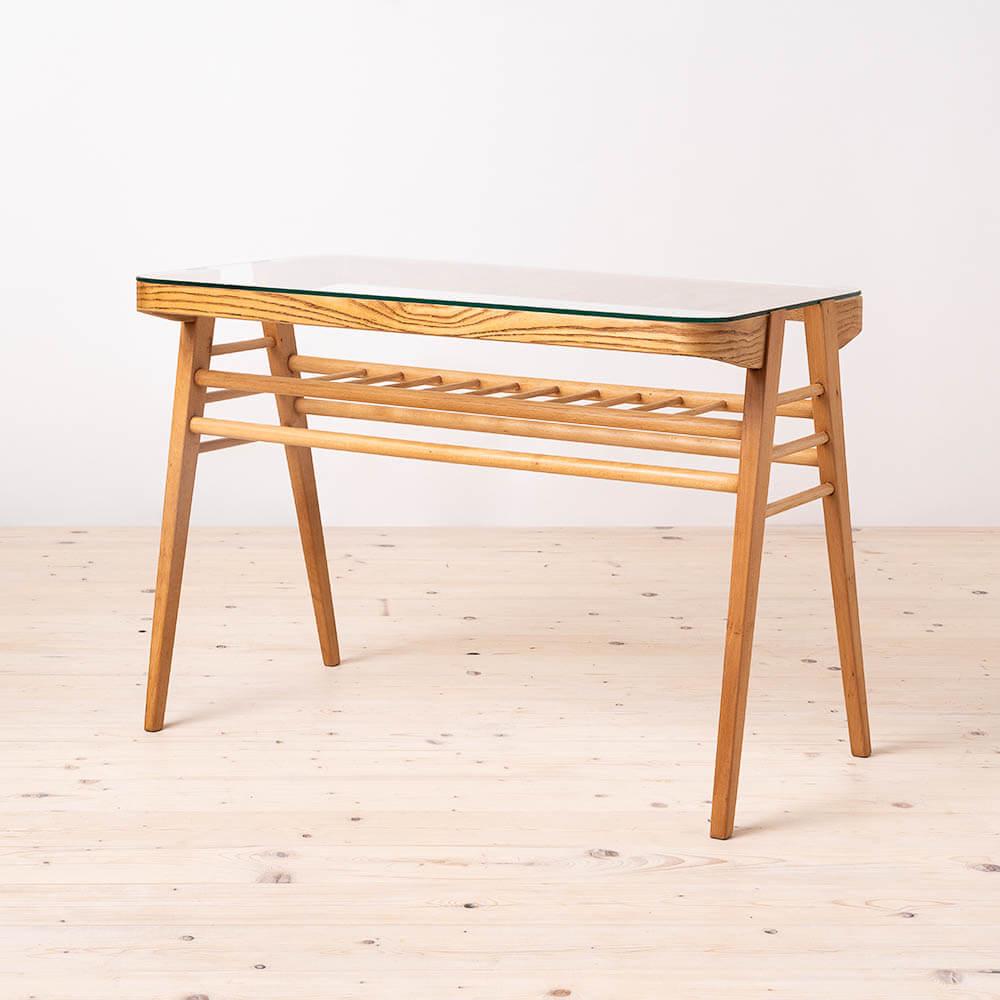 This coffee table was designed by Frantisk Jirak in the 1960s and was manufactured by ÚLUV – Ústredí Lidové Umelecké Výroby. Nicely shaped wooden base features a rung shelf for magazines, newspapers or books. Tabletop is made of glass which gives