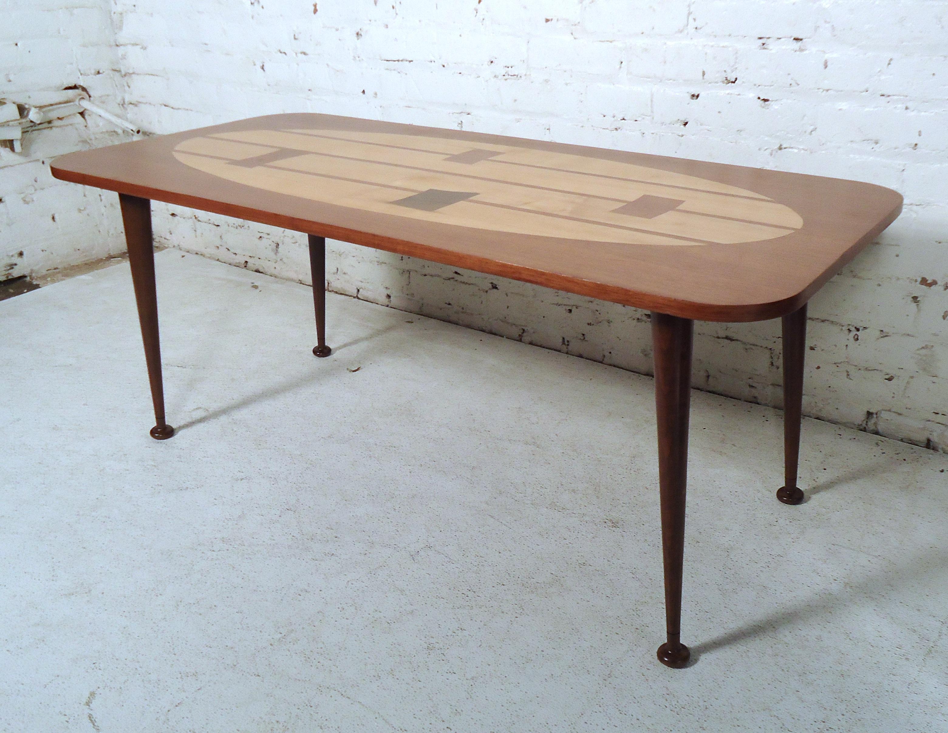 Vintage modern coffee table featuring a modern inlay design top, rich walnut grain, and tapered legs.

Please confirm item location (NY or NJ).