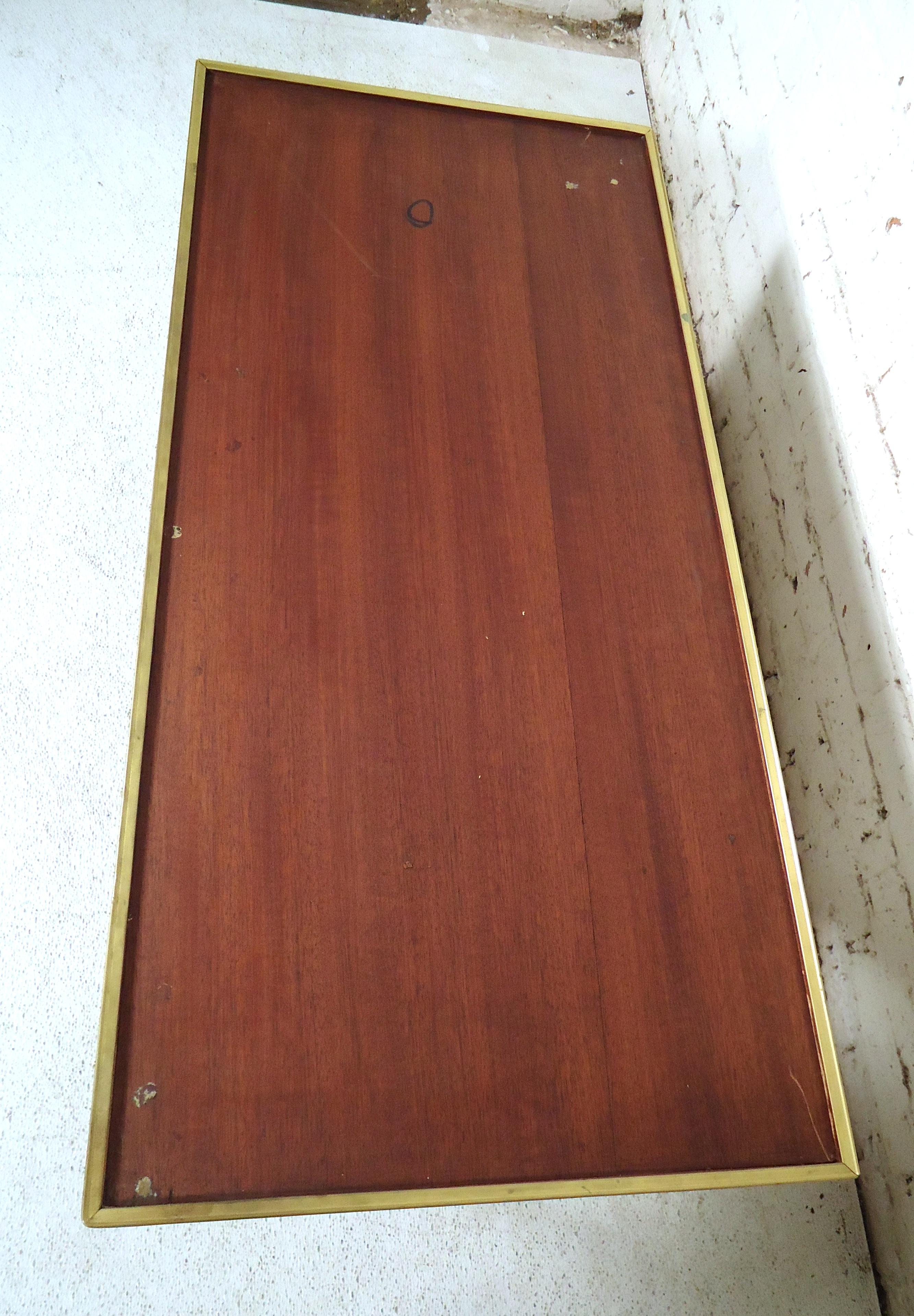 Vintage modern coffee table featuring rich walnut grain, brass frame and legs.

Please confirm item location (NY or NJ.)
