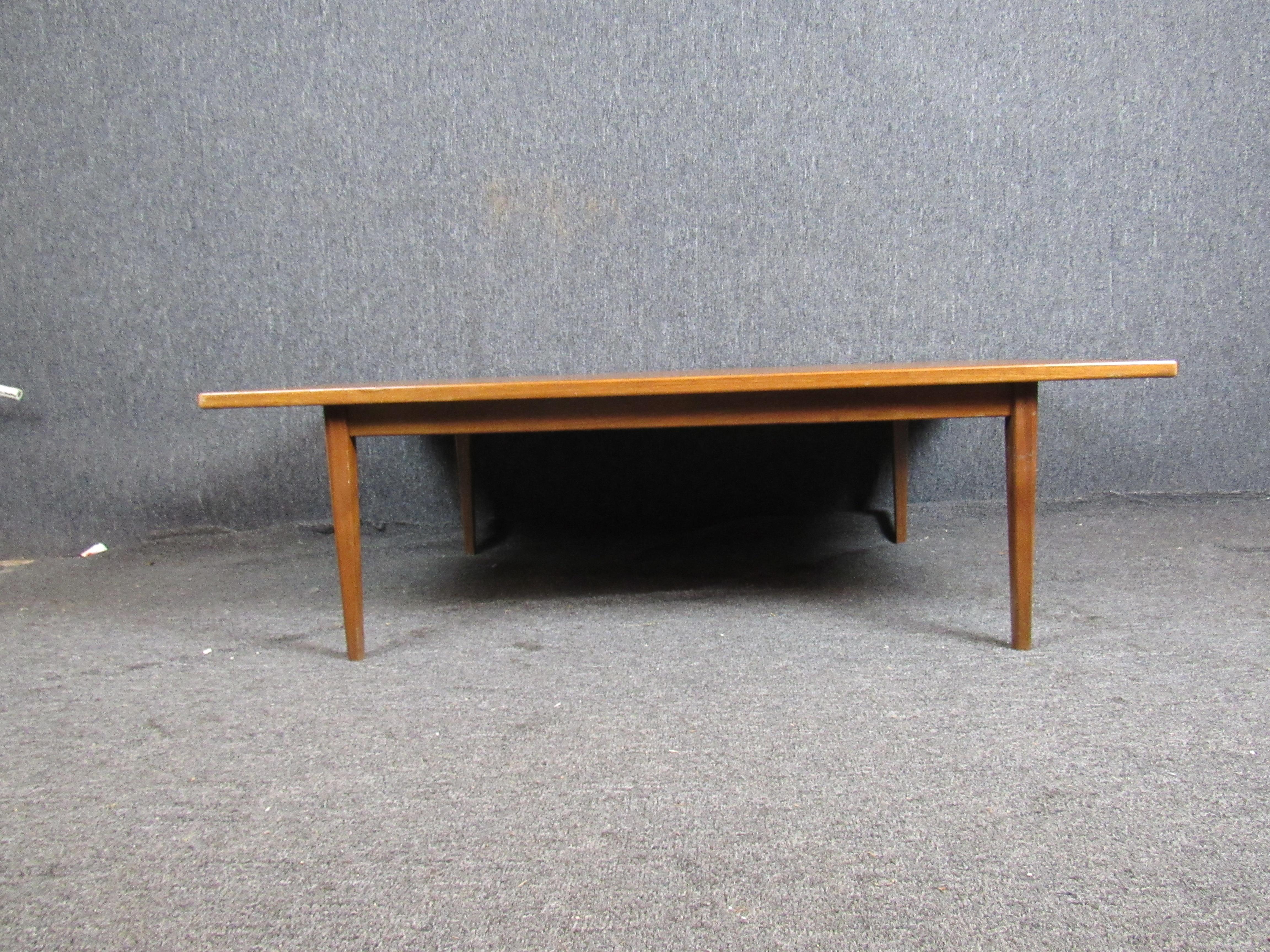 Mid-Century Modern walnut coffee table. Rather than your common long and narrow coffee table, this coffee table is closer to a square. 
Please confirm item pickup location (New York or New Jersey) with dealer.