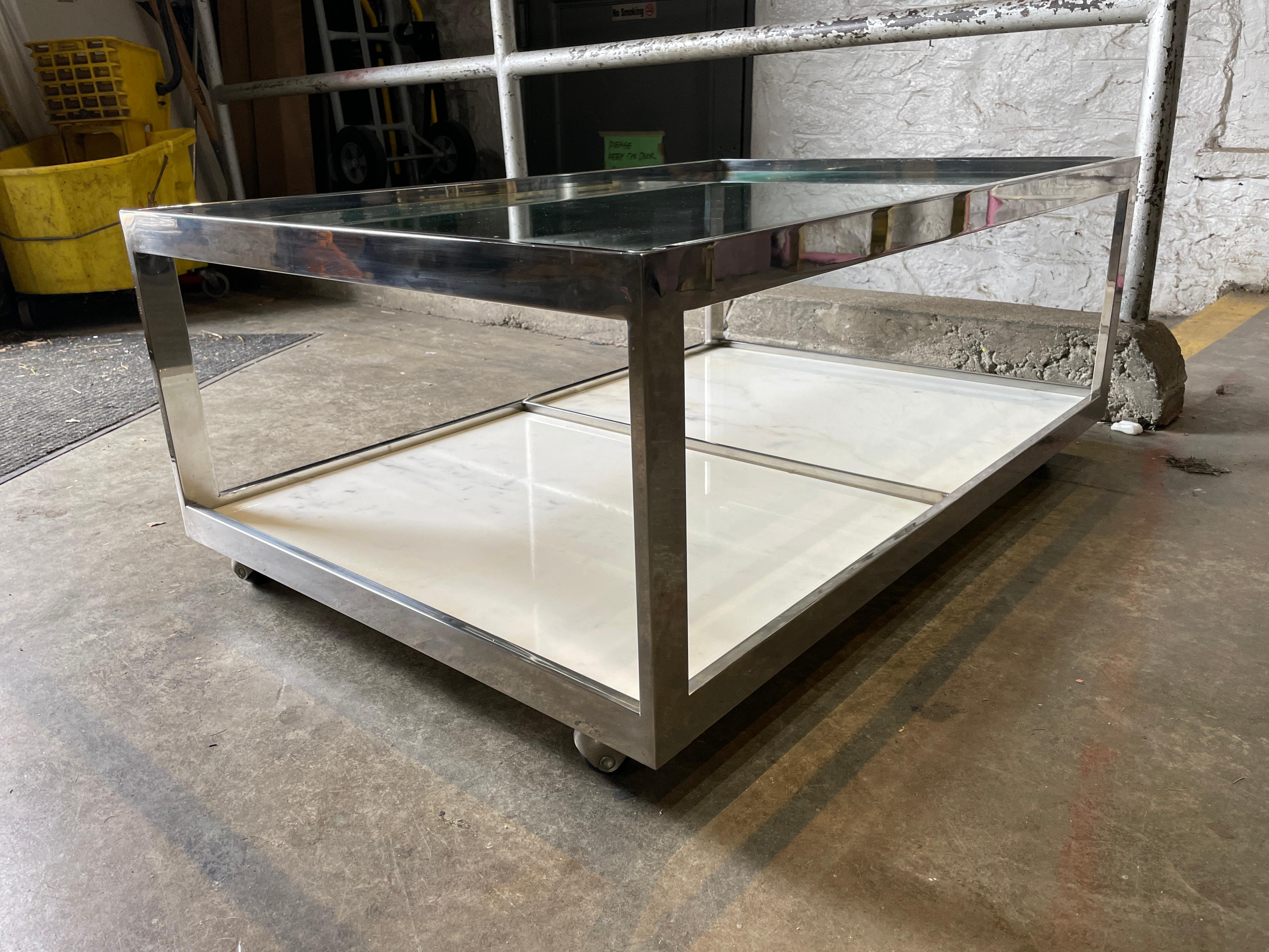 Mid-Century Modern 1970s Glass & marble coffee table with a chrome flat bar frame on casters. Located in Brooklyn NYC

Measures
38” x 25” x 16” high including casters
 