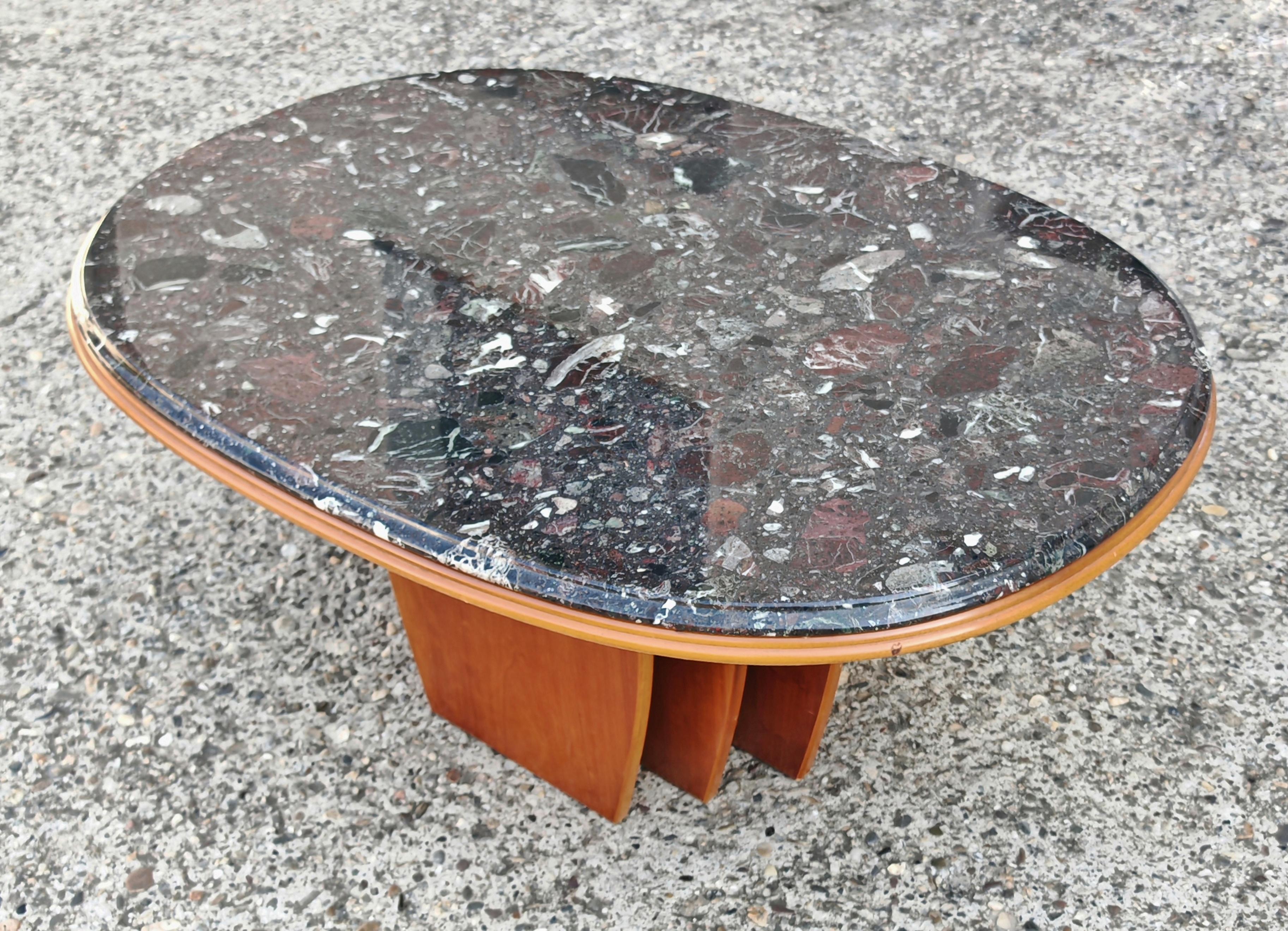 In this listing you will find a stunning oval Mid Century Modern Coffee or Cocktail table attr. to Bendixen Design. It features a sleek oval top in black granite and a very sculptural base done in cherry wood. The table was made in Denmark in the