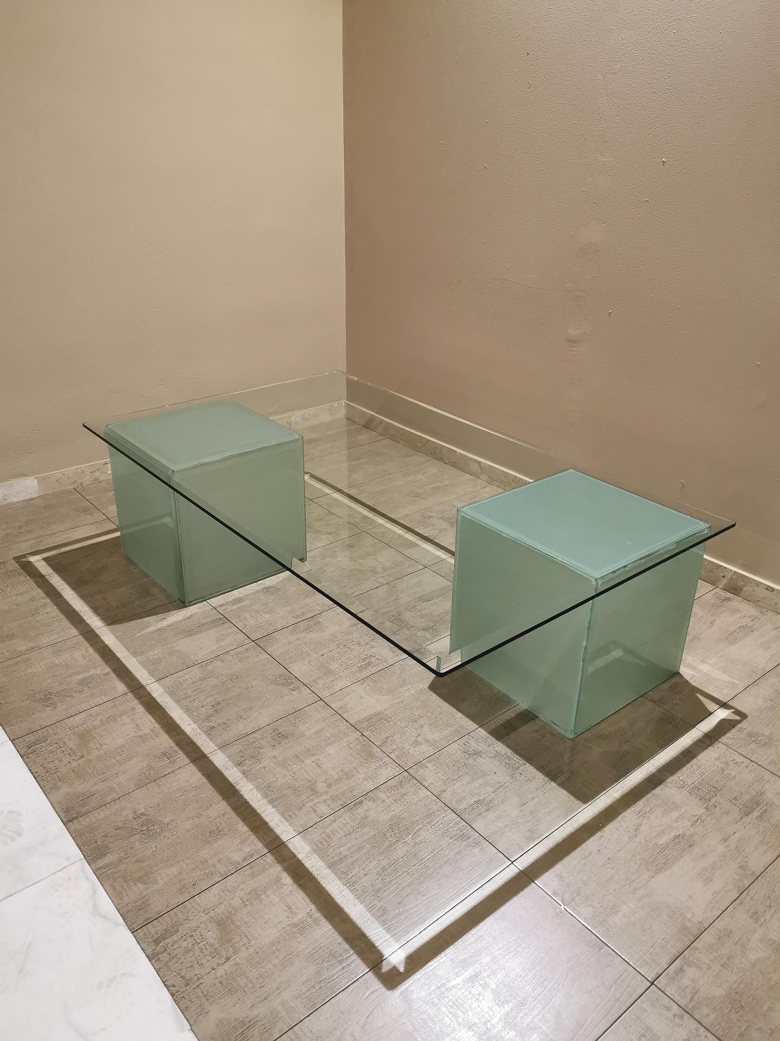 Large coffee table with rectangular cut transparent glass top that rests on 2 cubes of a particular frosted glass that gives water green reflections. The characteristic of this piece are the 2 cubes that can be arranged to your taste being