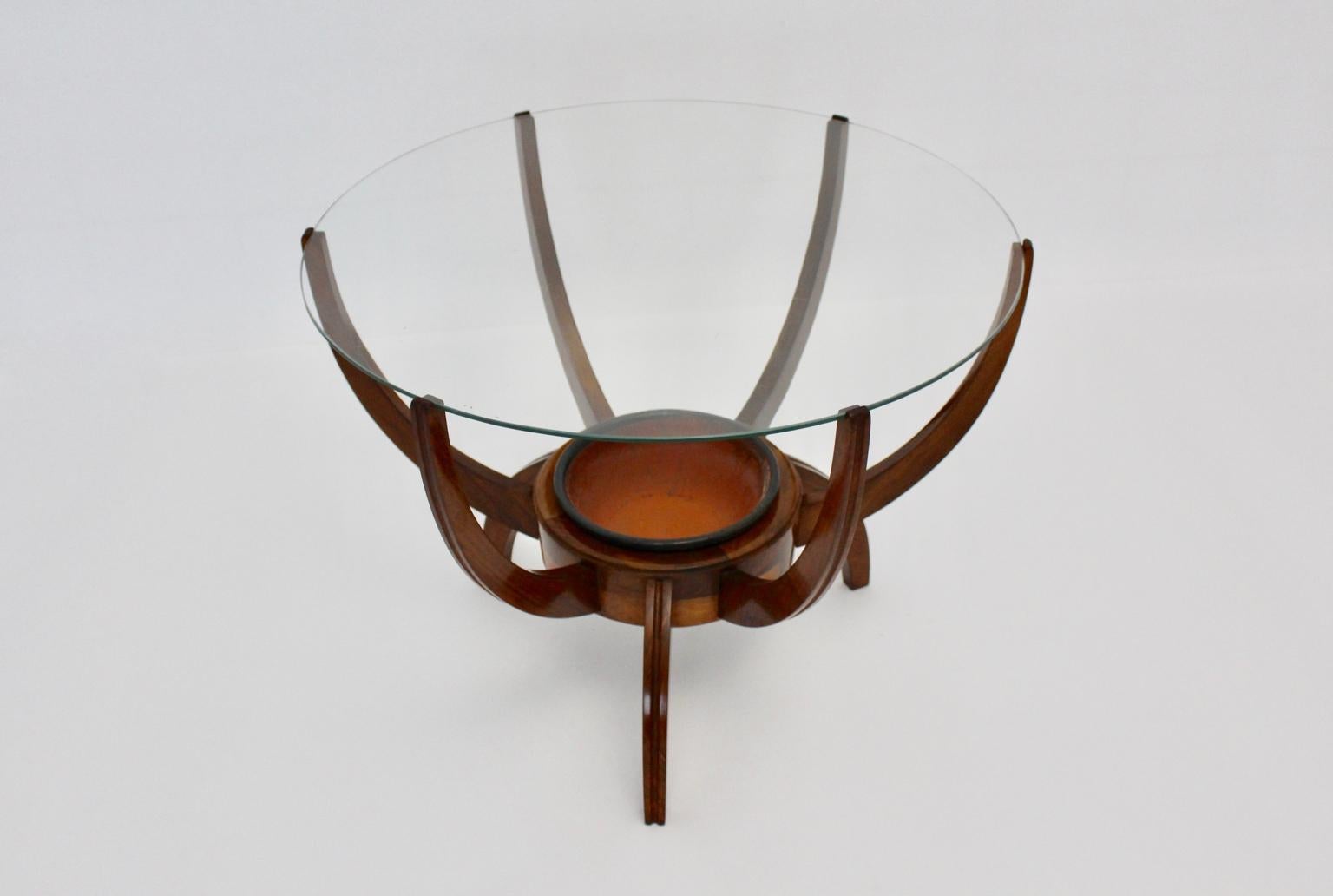Mid century modern vintage walnut coffee table, which was designed in the style of Carlo di Carli 1950s.
At the center of the base is a ceramic bowl as a removable insert,  which is great to decorate with plants or flowers or for fruits and sweets.