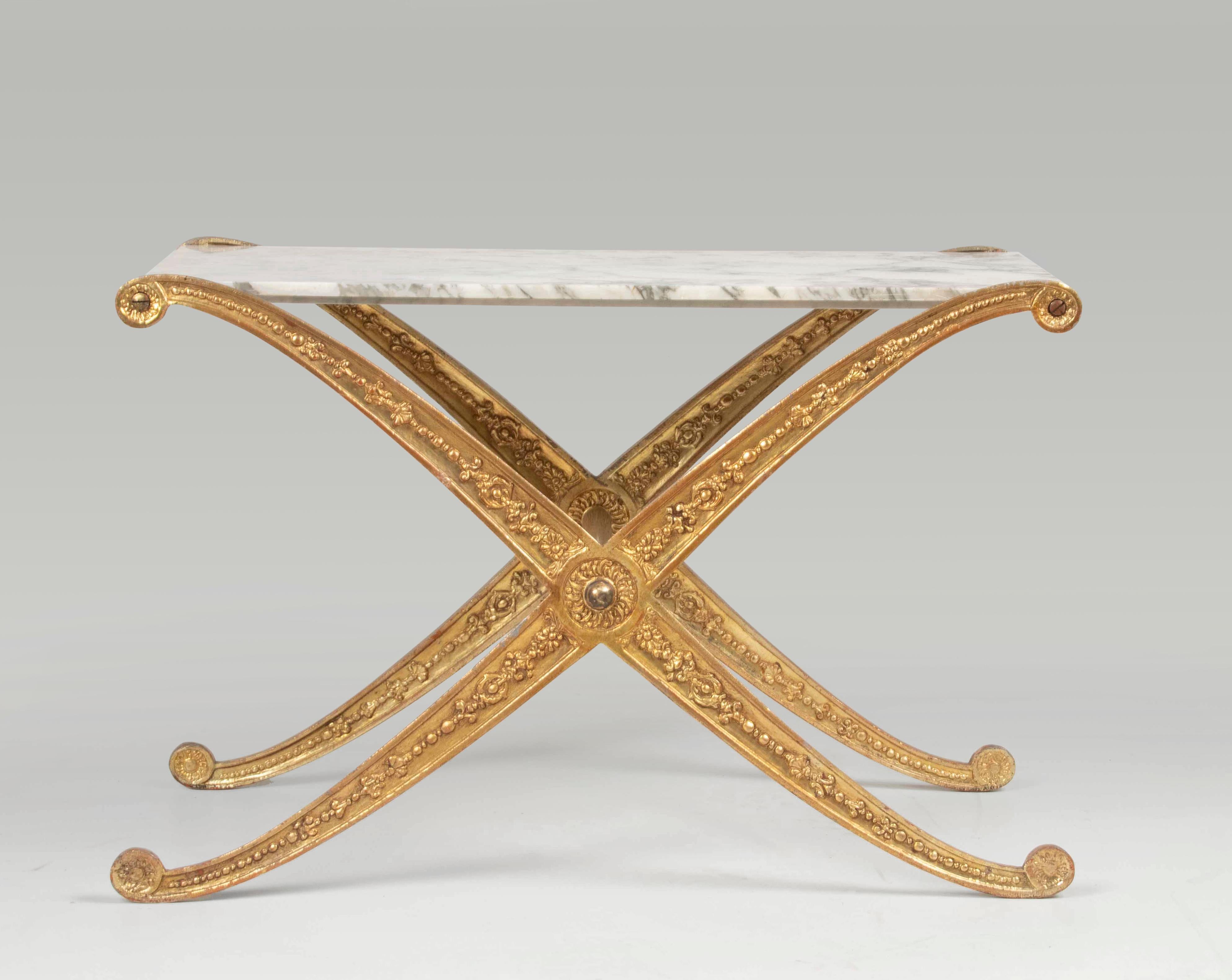 Beautiful vintage side table by the Italian maker Palladio. The base is made of cast iron, patinated in a gold color. Also known as 'Curule', this cross-legged model has its origins in the Roman Empire.
The top of the table is made of white marble
