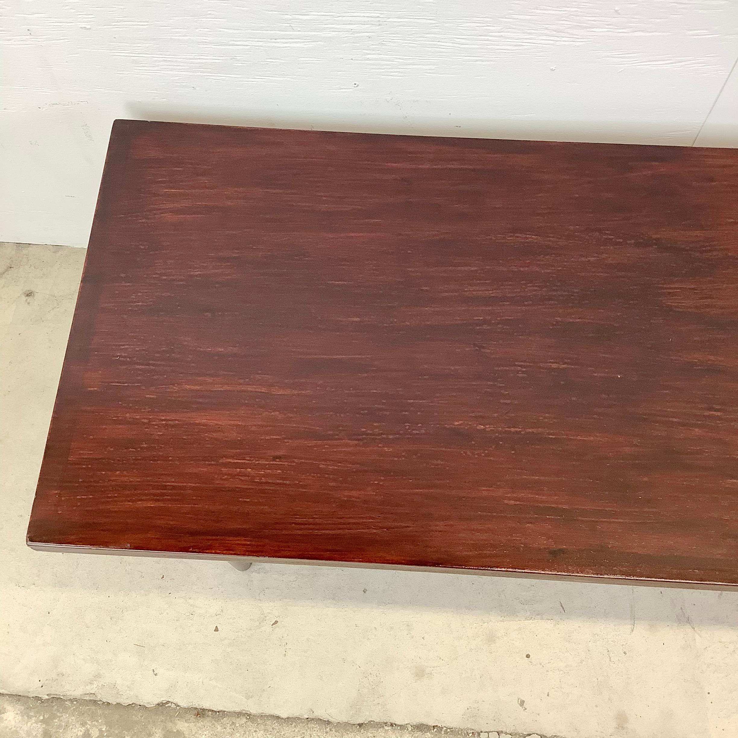 Cette table basse mid-century simple mais frappante présente des lignes modernes épurées et une construction en bois vintage avec une finition sombre. Les pieds fuselés et la construction robuste font de cette table une table basse idéale pour un