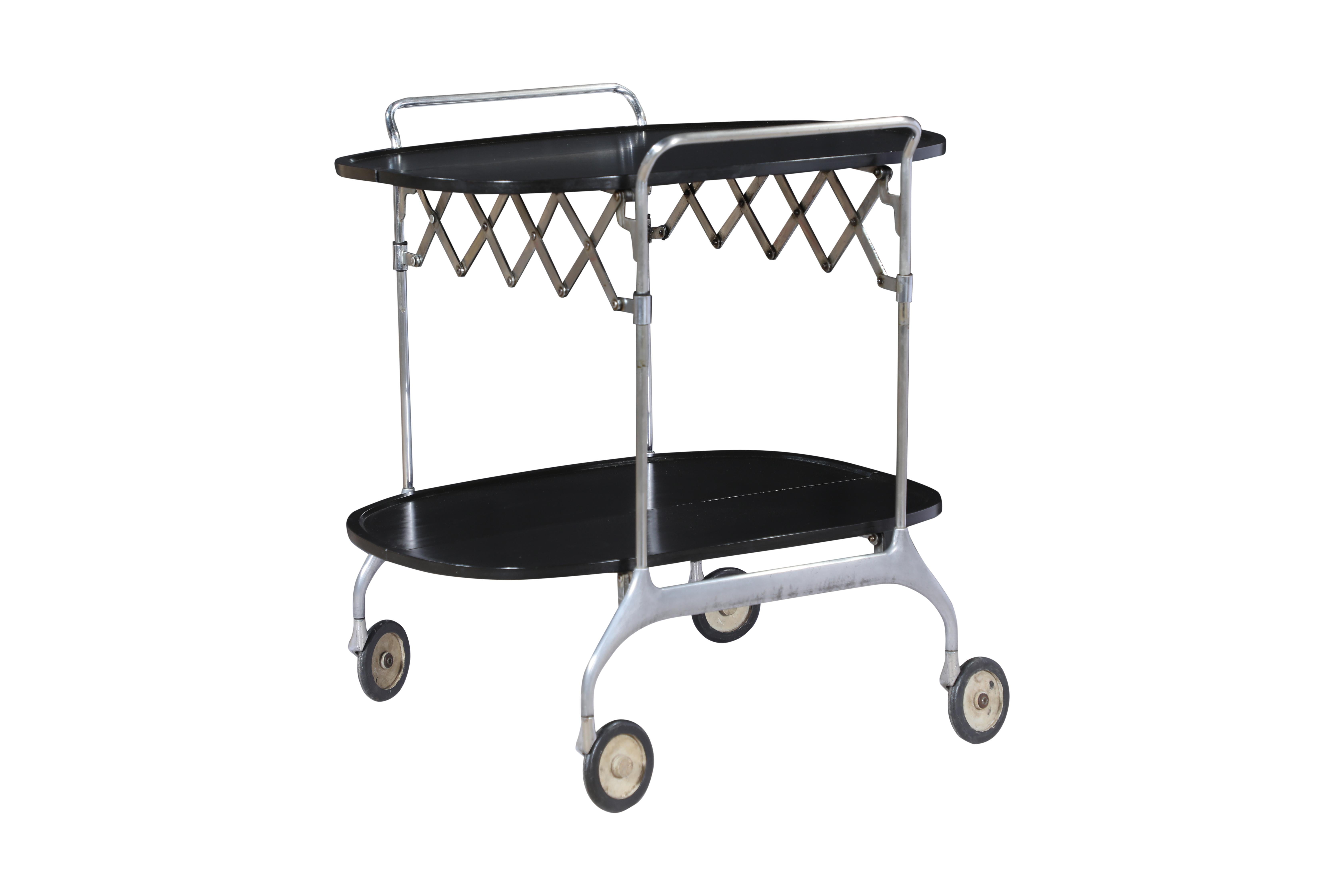 This is a rare and unusual Mid-Century Modern piece. A folding bakelite and chrome bar cart from the 1960's. The chrome accordion structure allows you to fold the bar cart up and store it away. Two handles on the sides and swivel feet for