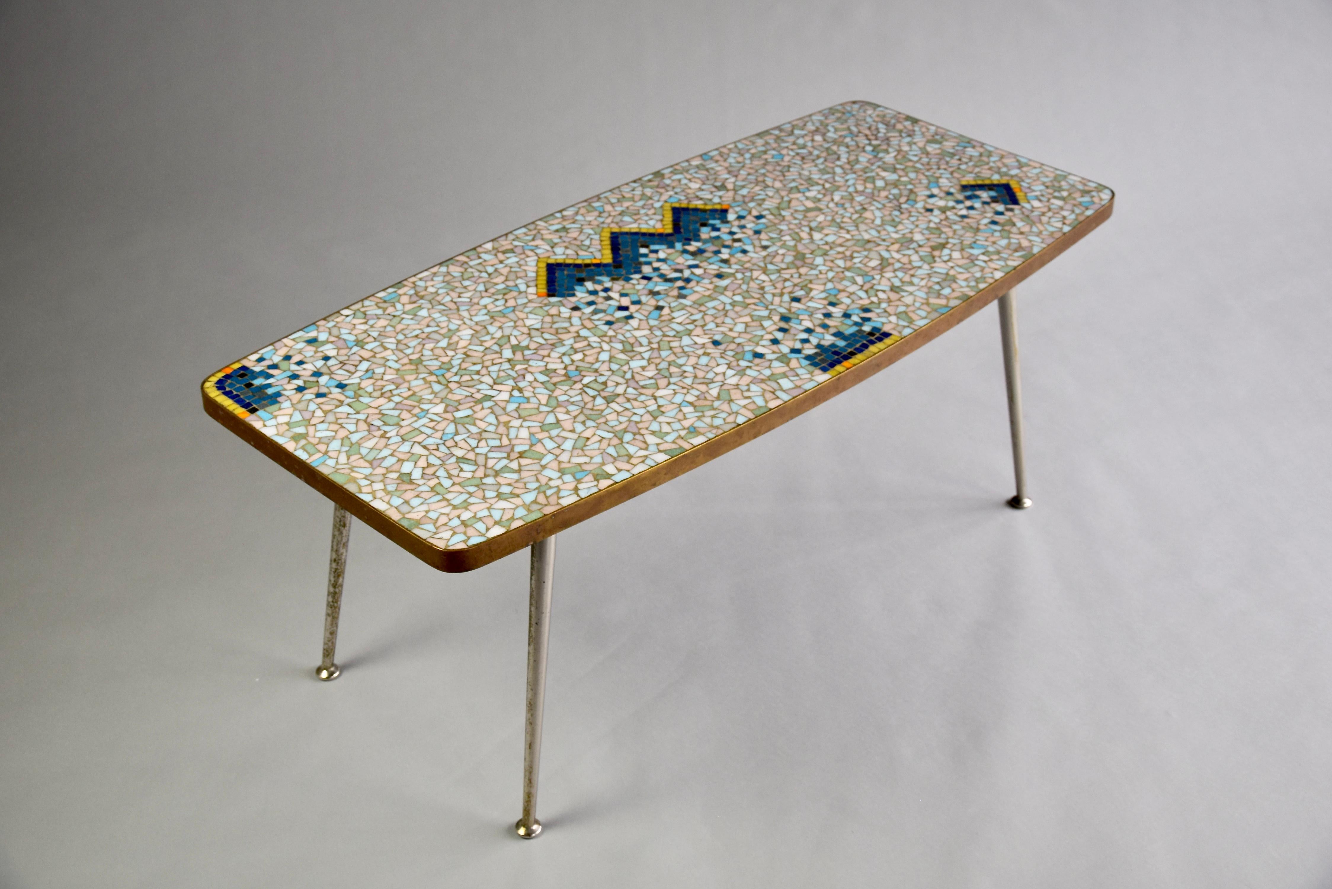 Table basse en mosaïque colorée et laiton de l'artiste Berthold Muller. Toutes les créations de Berthold Muller sont uniques. Les carreaux de mosaïque sont disposés selon un magnifique motif abstrait, qui rappelle l'art moderne de l'époque. Le