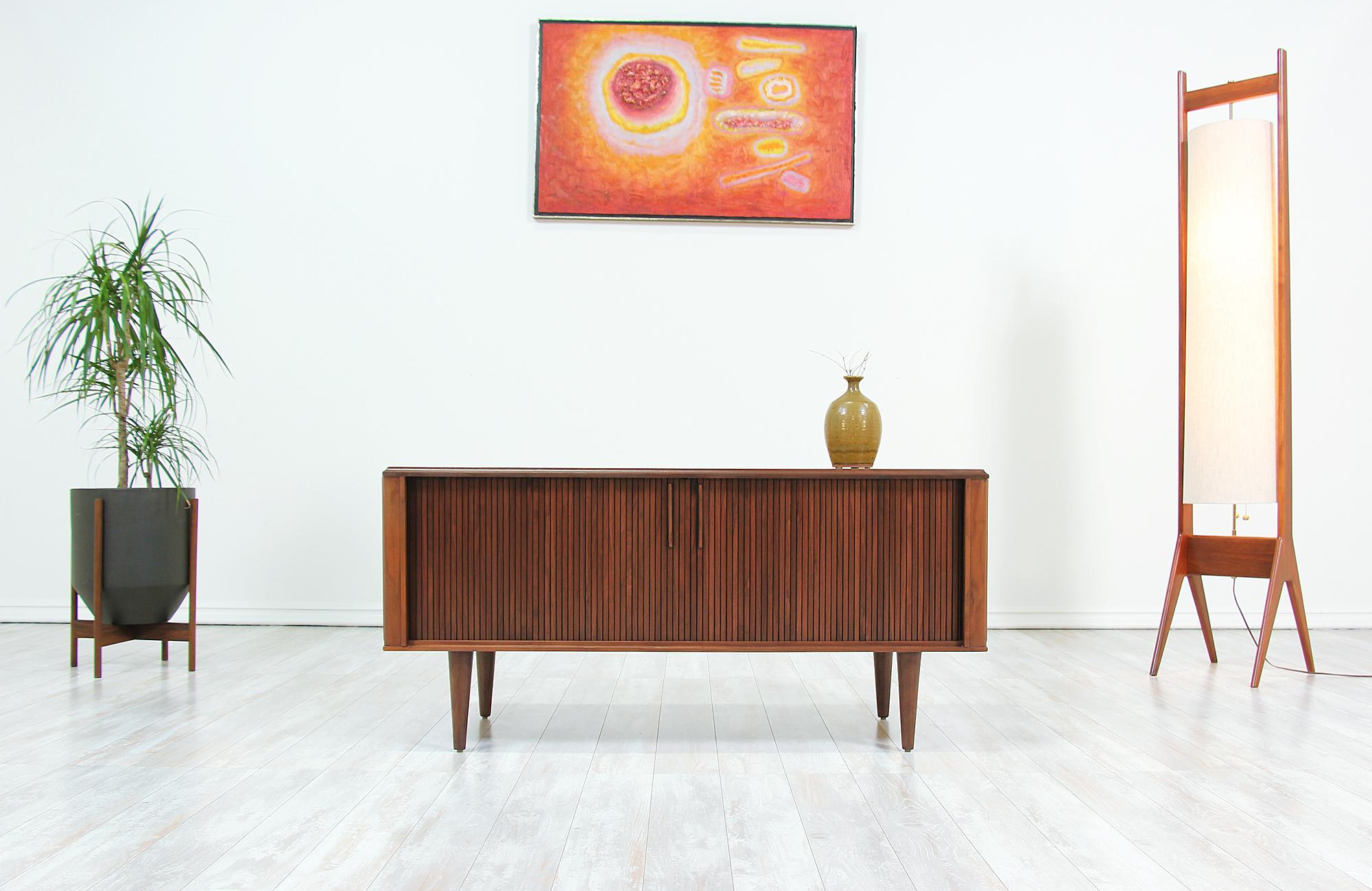 Mid-Century Modern tambour door credenza designed and manufactured in the United States by Barzilay in the 1960s. Low in profile and compact in size, this beautifully refinished walnut storage unit is accented with inconspicuous door pulls for