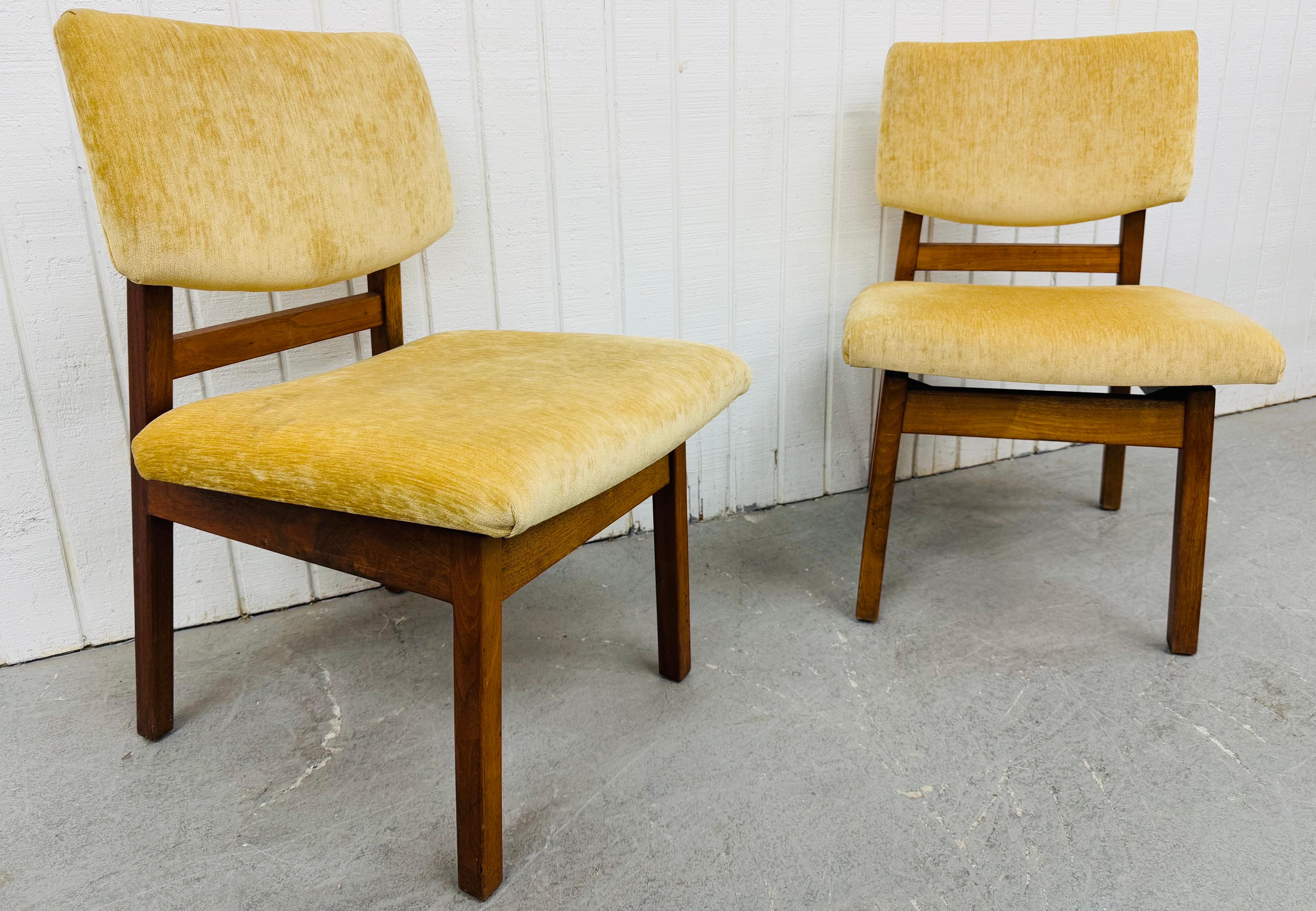 This listing is for a pair of Mid-Century Modern Conant Ball Walnut Side Chairs. Featuring a straight line design, newly reupholstered seat/back rest, solid wooden frame, and a beautiful walnut finish. This is an exceptional combination of quality