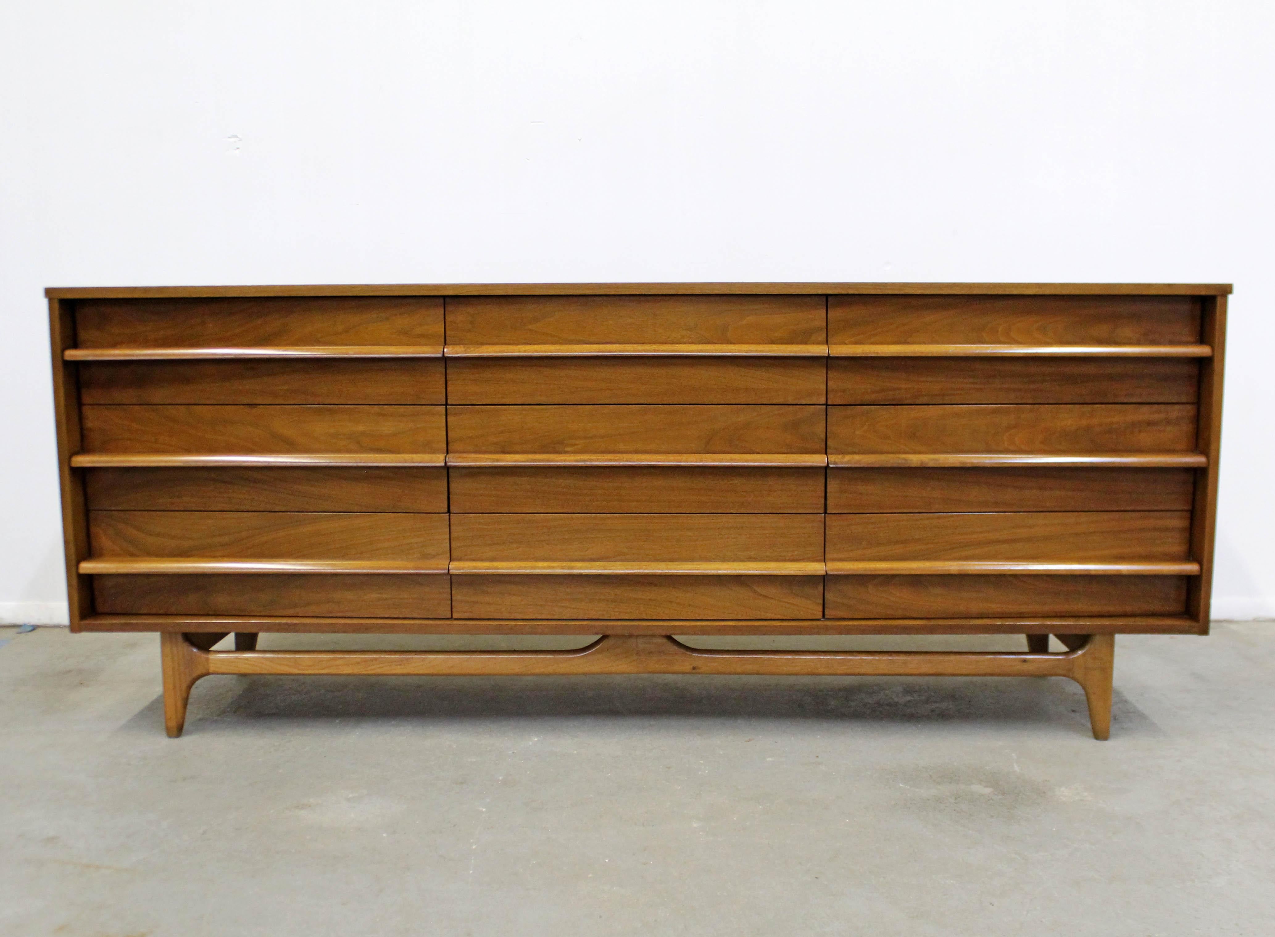 Offered is a vintage Mid-Century Modern concave front credenza with sculpted pulls made by Young Manufacturing. Features a concave front, nine dovetailed drawers, and sculpted pulls. It is in overall good vintage condition with slight surface