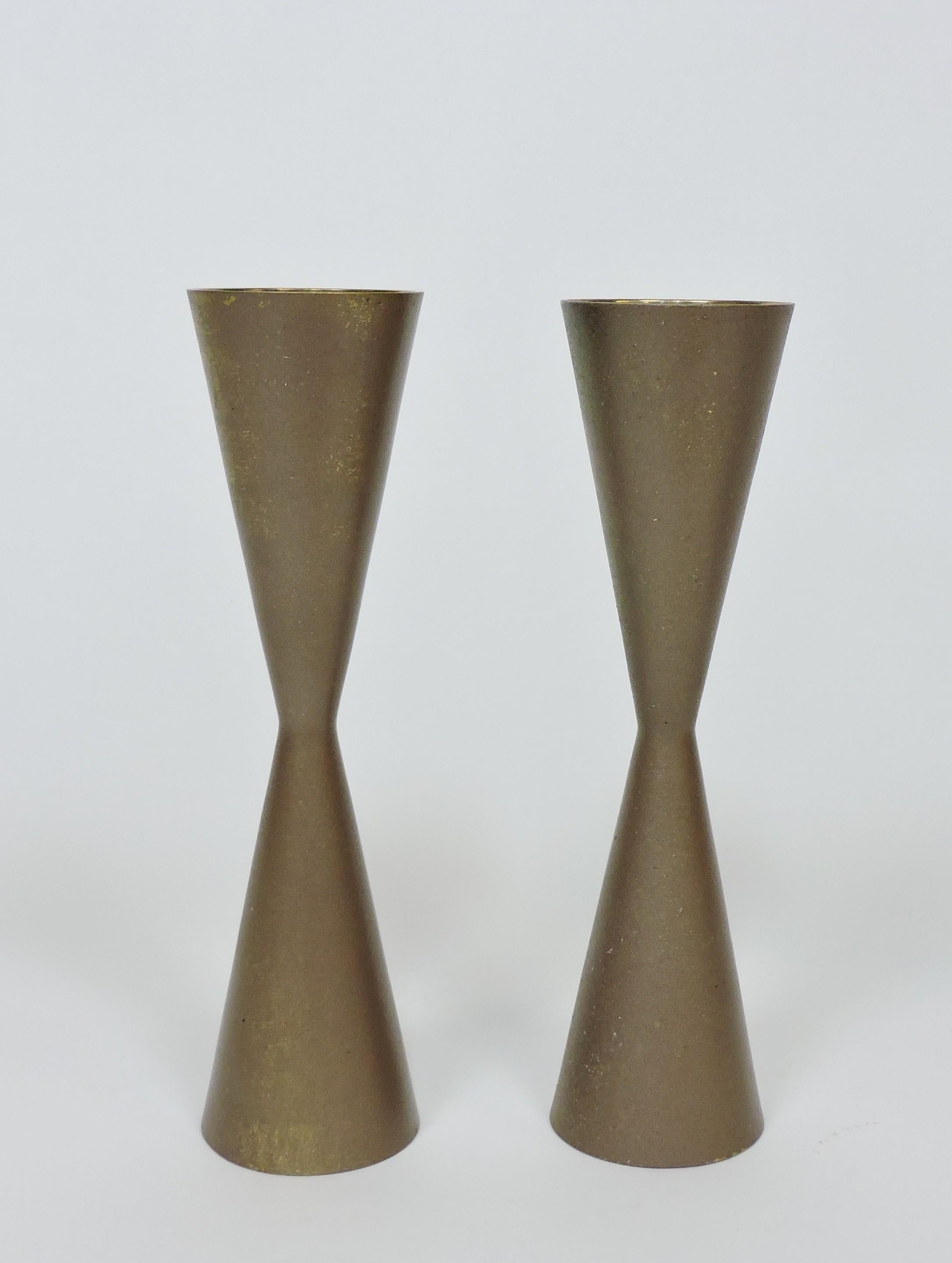 Portacandele di metà secolo molto belli a forma di doppio cono. Questi bastoncini per candele sono realizzati in ottone massiccio e hanno una finitura leggermente strutturata. Uno ha l'etichetta originale.  Una creazione di Venere, Giappone. Ce ne