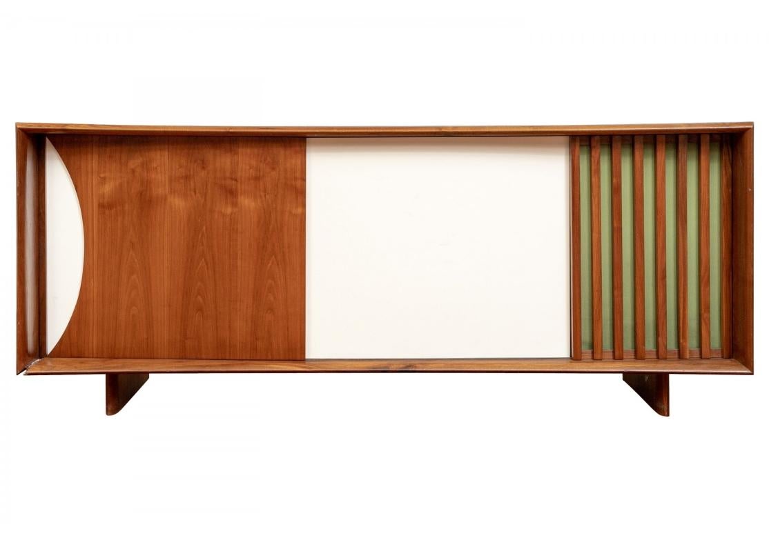 Midcentury Modern console cabinet with right side door having slatted mesh construction, one section with slide out shelf and adjustable shelving, left side with three pull out drawers, pierced venting on back.

Dimensions: 84