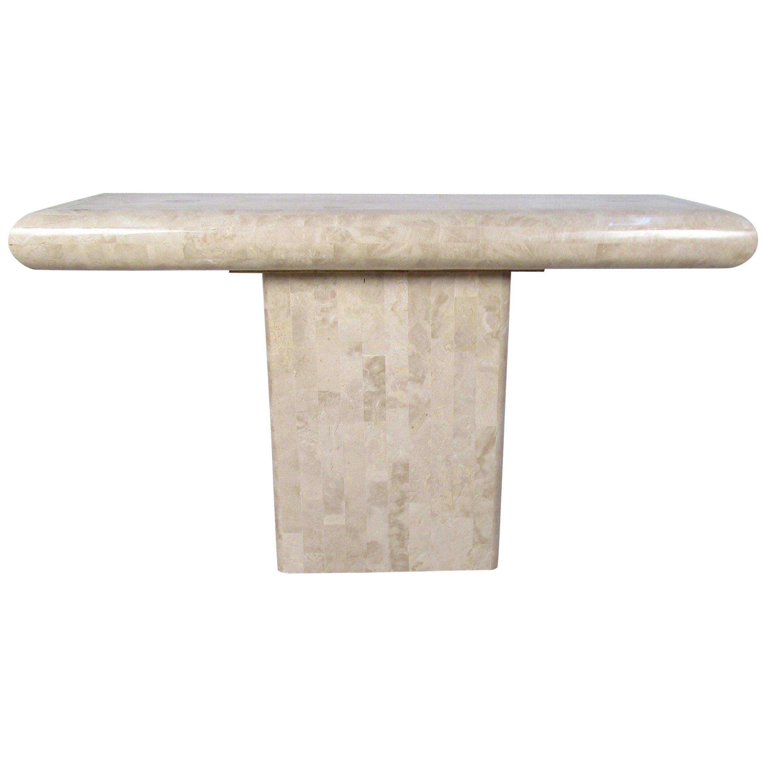 This stunning hall table by Maitland smith boasts a tessellated stone top and a pedestal base. A stylish design that looks great behind the sofa, in the hallway, or even in the entryway. Wonderful beveled edges along the top add to the midcentury