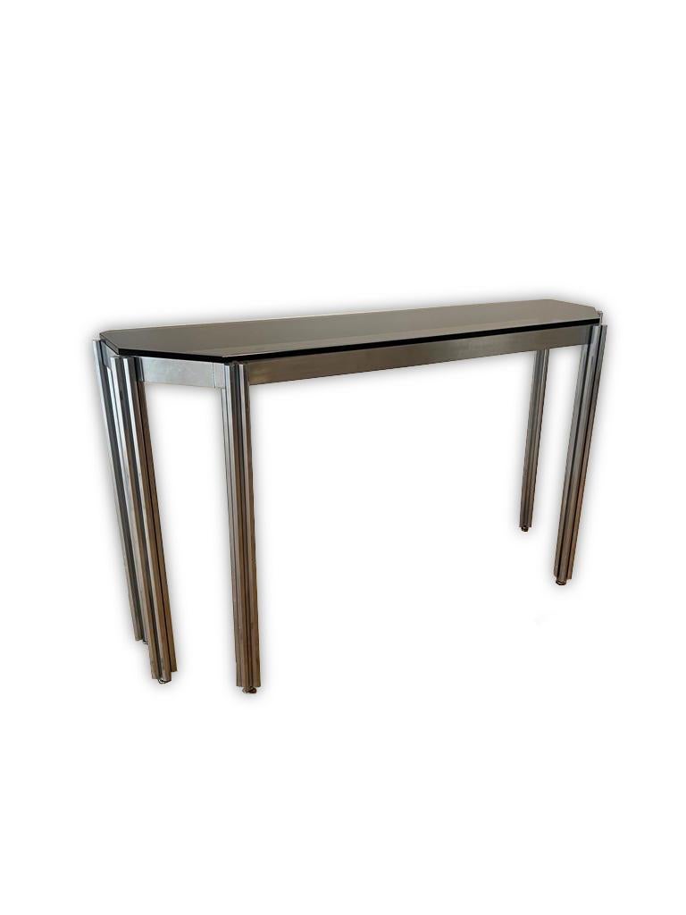 This elegant Mid-Century Modern console table was designed by Alessandro Albrizzi. The table is in chrome featuring six legs made up of octagonal bars with a dark glass top. 

Property from esteemed interior designer Juan Montoya. Juan Montoya is