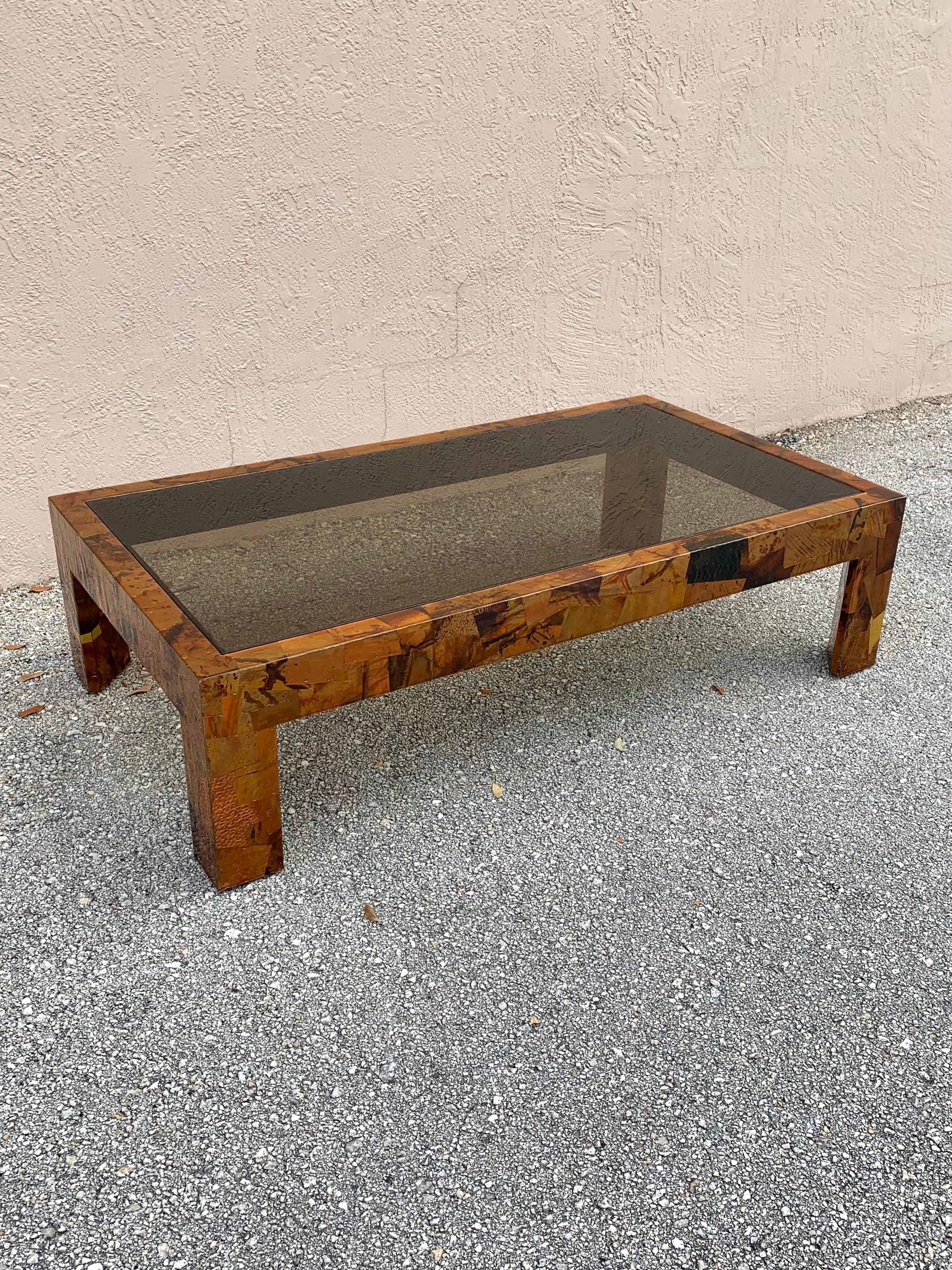 Studio made copper and brass coffee table. Made to have a brutalist flair. The artist used different pieces of textured and patinated copper and clean brass to cover the entire coffee table. The plates are affixed with copper staples then covered