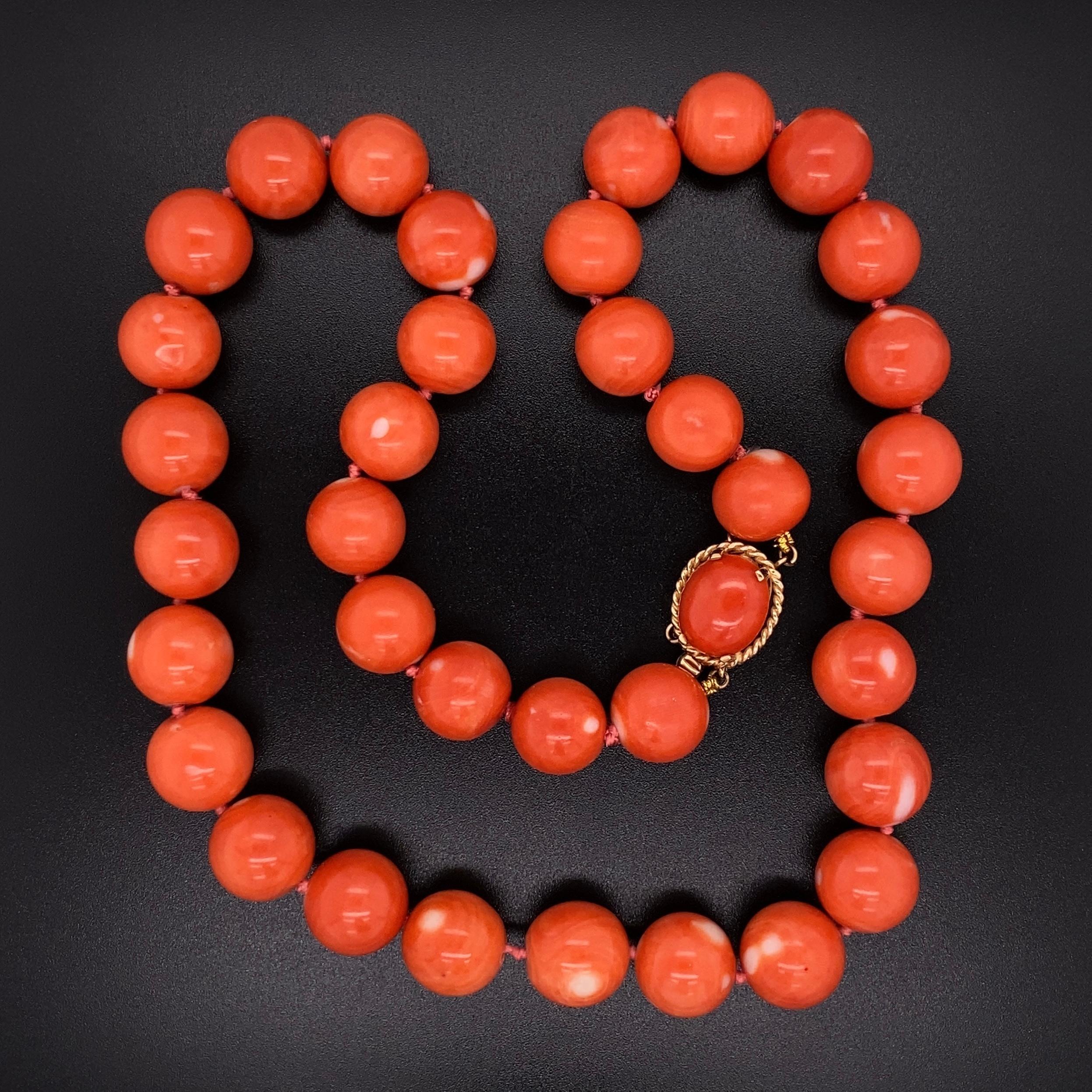 Simply Beautiful! 36 Round Bead Pacific Coral Necklace, each measuring approx. 11.50mm, held by a 14K Yellow Gold clasp inset with Coral. Hand strung with matching silk cord. The necklace measures approx. 17.75” long. Circa: 1960s. More Beautiful in