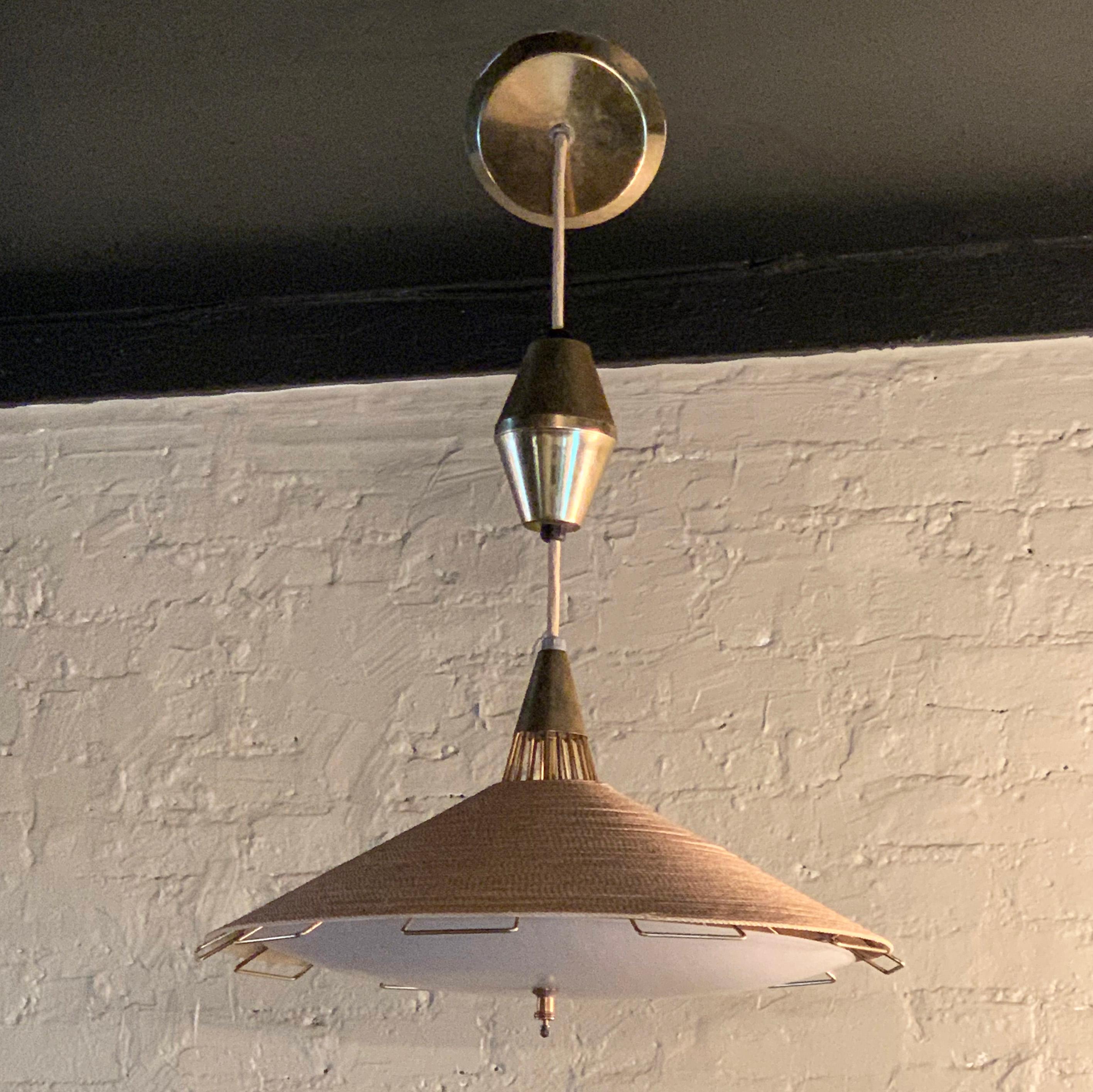 Mid-Century Modern, pendant light by Moe Light features a whirl cord wrapped disc shade with fiberglass diffuser and brass wire detail, has a spring loaded height adjustment from 28 - 40 inches.