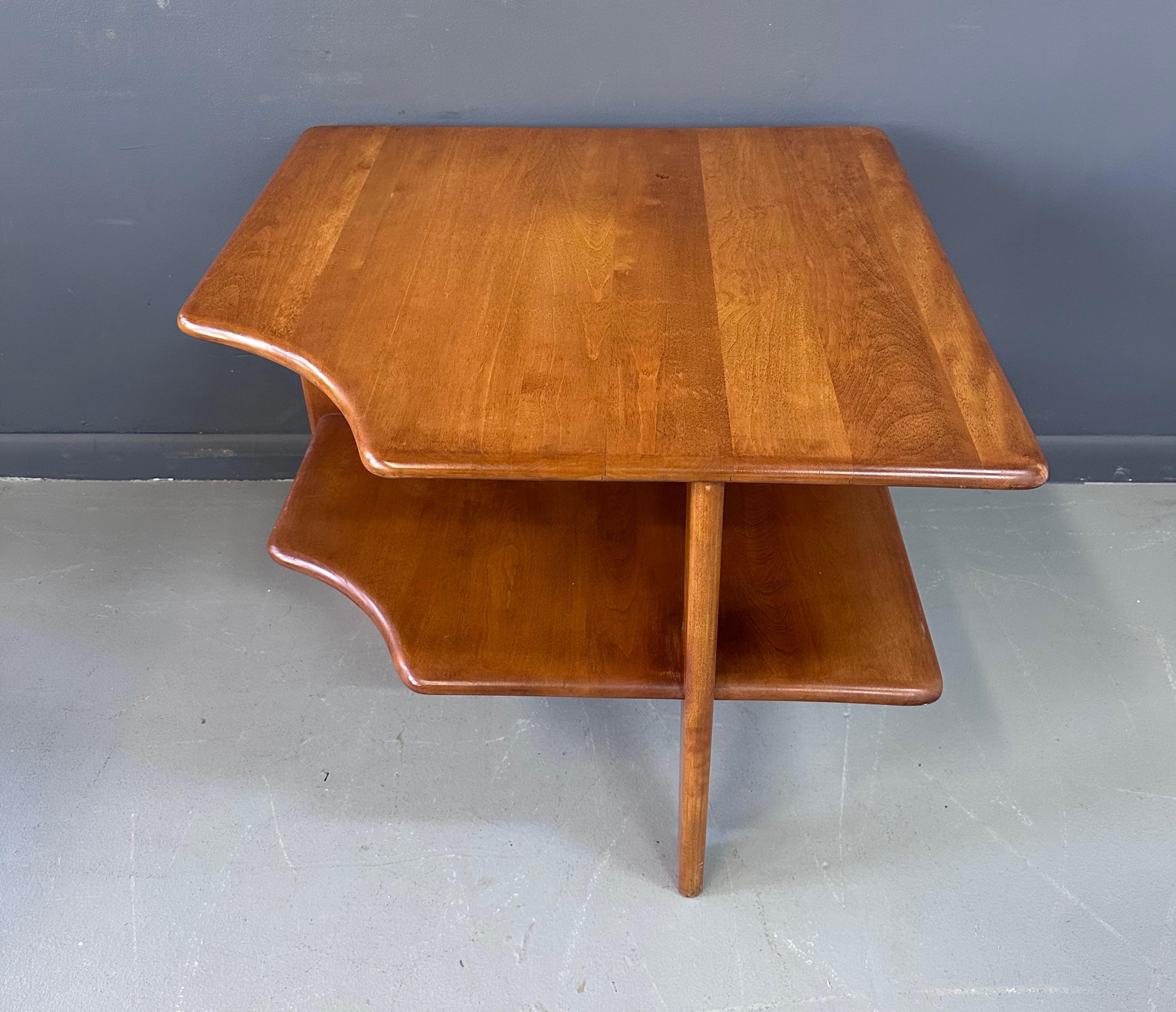 Sculptural, Mid-Century Modern, tiered maple, corner side table by Russel Wright for Conant ball features a carved edge to create a corner in between sofas or chairs. The bottom tier is 12 inches height.