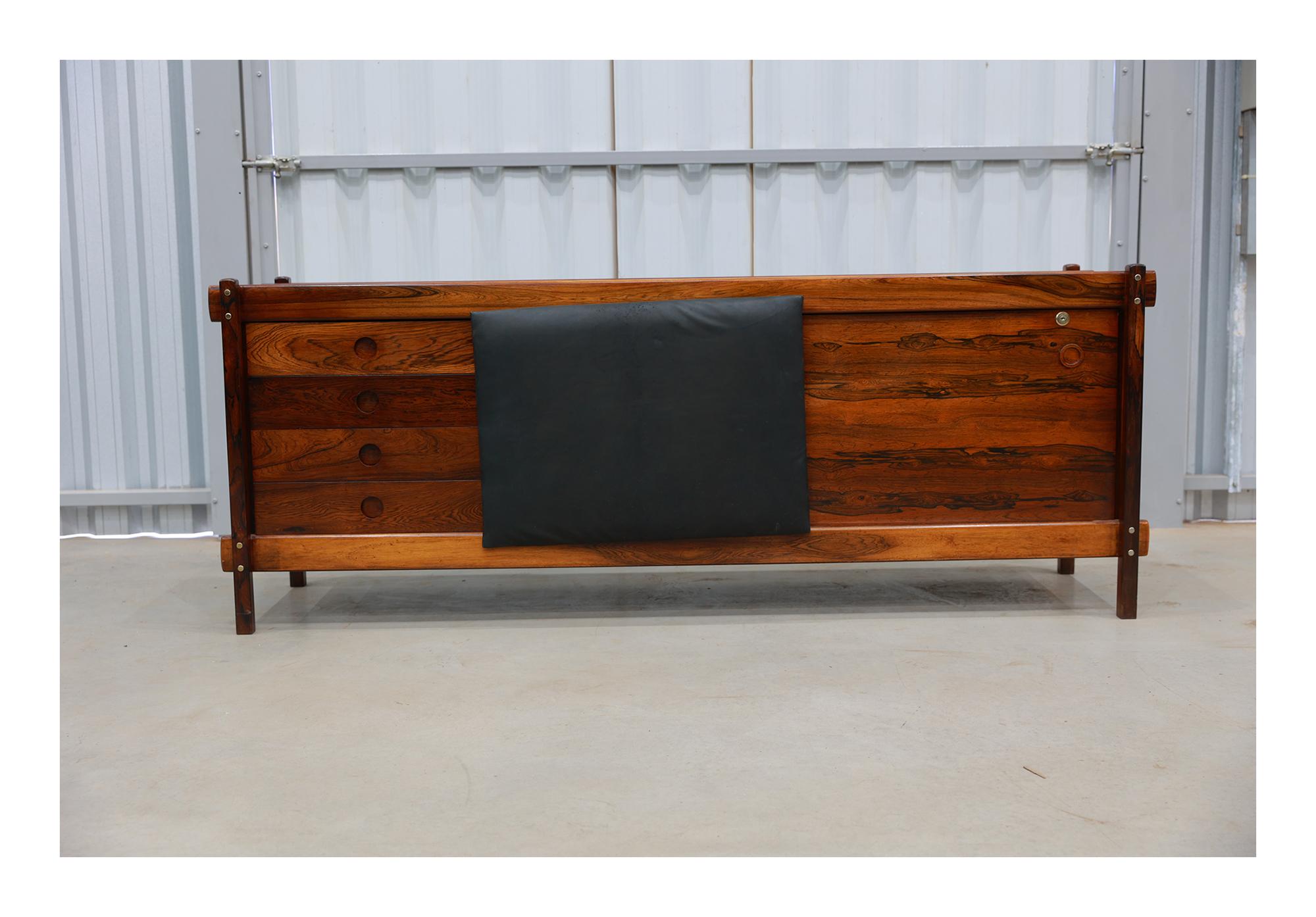 Available today, this Mid Century Modern Credenza “Adolpho” in hardwood by Sergio Rodrigues is stunning!

This wonderful credenza is made in solid Brazilian rosewood (Jacaranda). The sliding door is still upholstered in its original faux leather.
