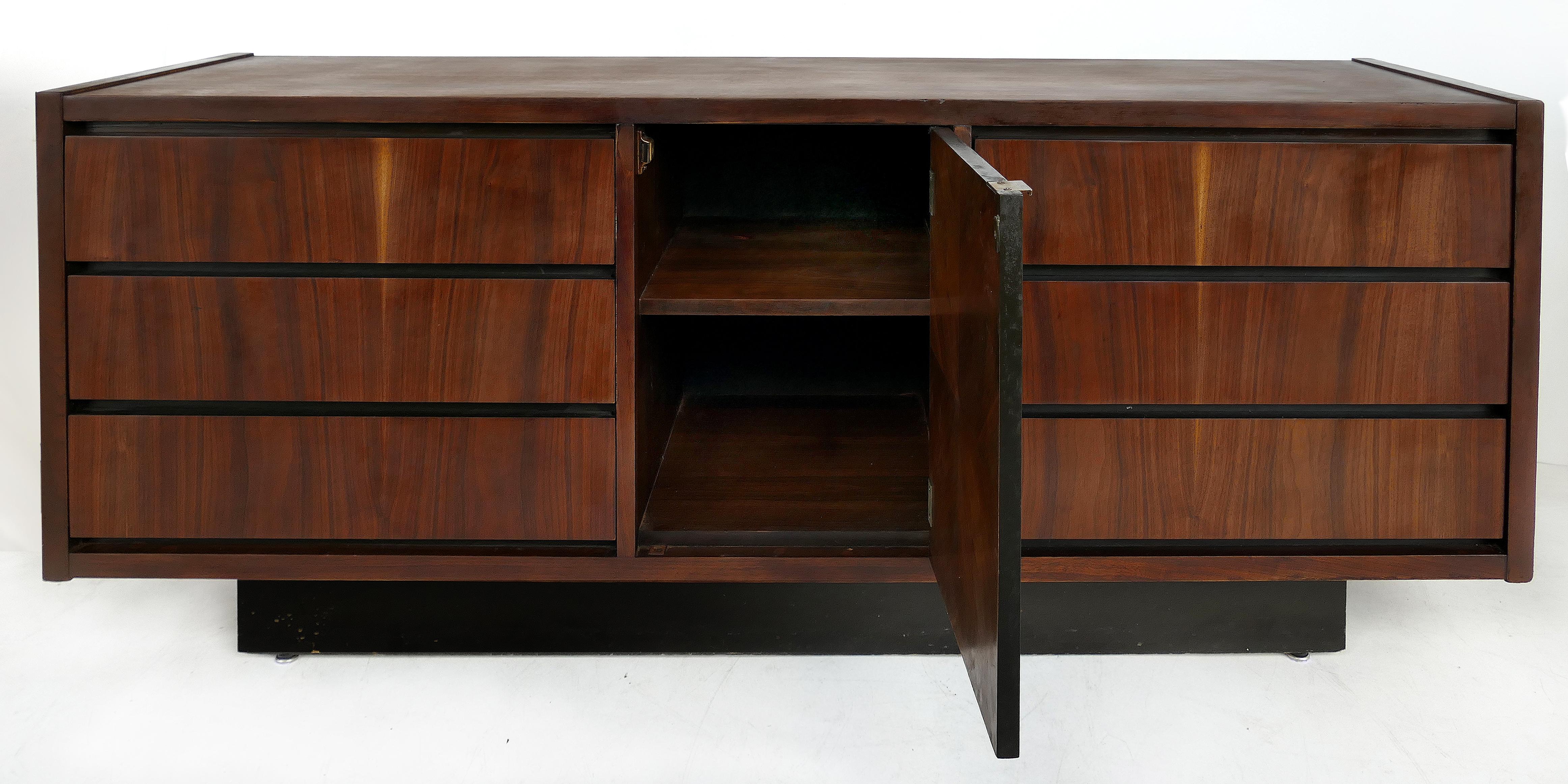 Mid-Century Modern credenza by Lane (Altavista, Virginia)

Offered for sale is a Lane (Altavista, Virginia) Mid-Century Modern credenza with center shelves and matched veneers. The center door offers ample shelving and is flanked by three drawers