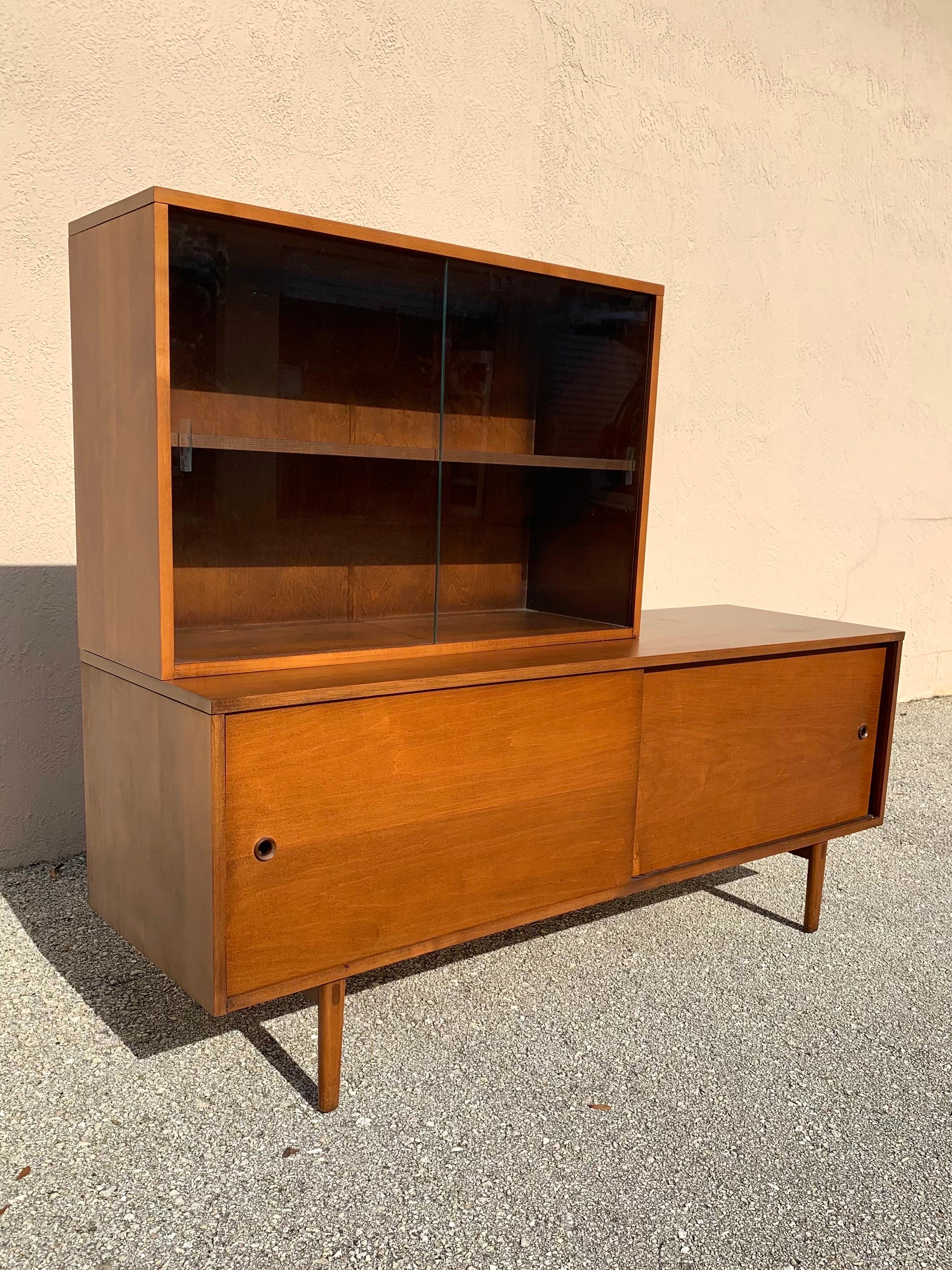 Time capsule condition low credenza/hutch by Paul McCobb for The Planner Group. Model #1513. Mostly solid wood construction with some veneer on the trim. A nice rich walnut finish. This is a rare version with the hutch top and rarely seen legs.