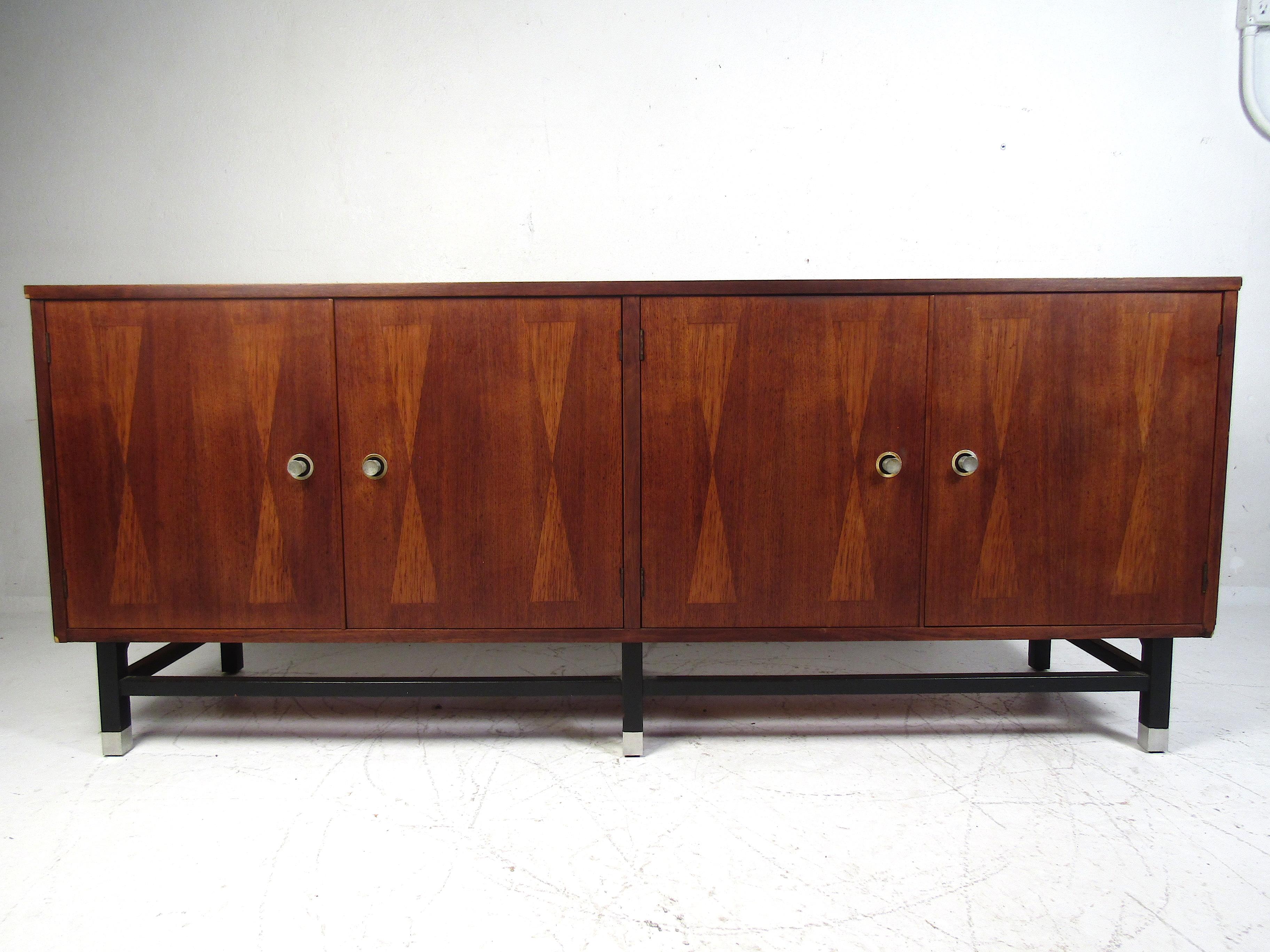 Stylish Mid-Century Modern dresser by Stanley. Cabinet with adjustable shelving on one side, with three dovetail-jointed drawers on the other side, the uppermost of which has a partitioned section. Walnut veneer exterior with bowtie inlays on the