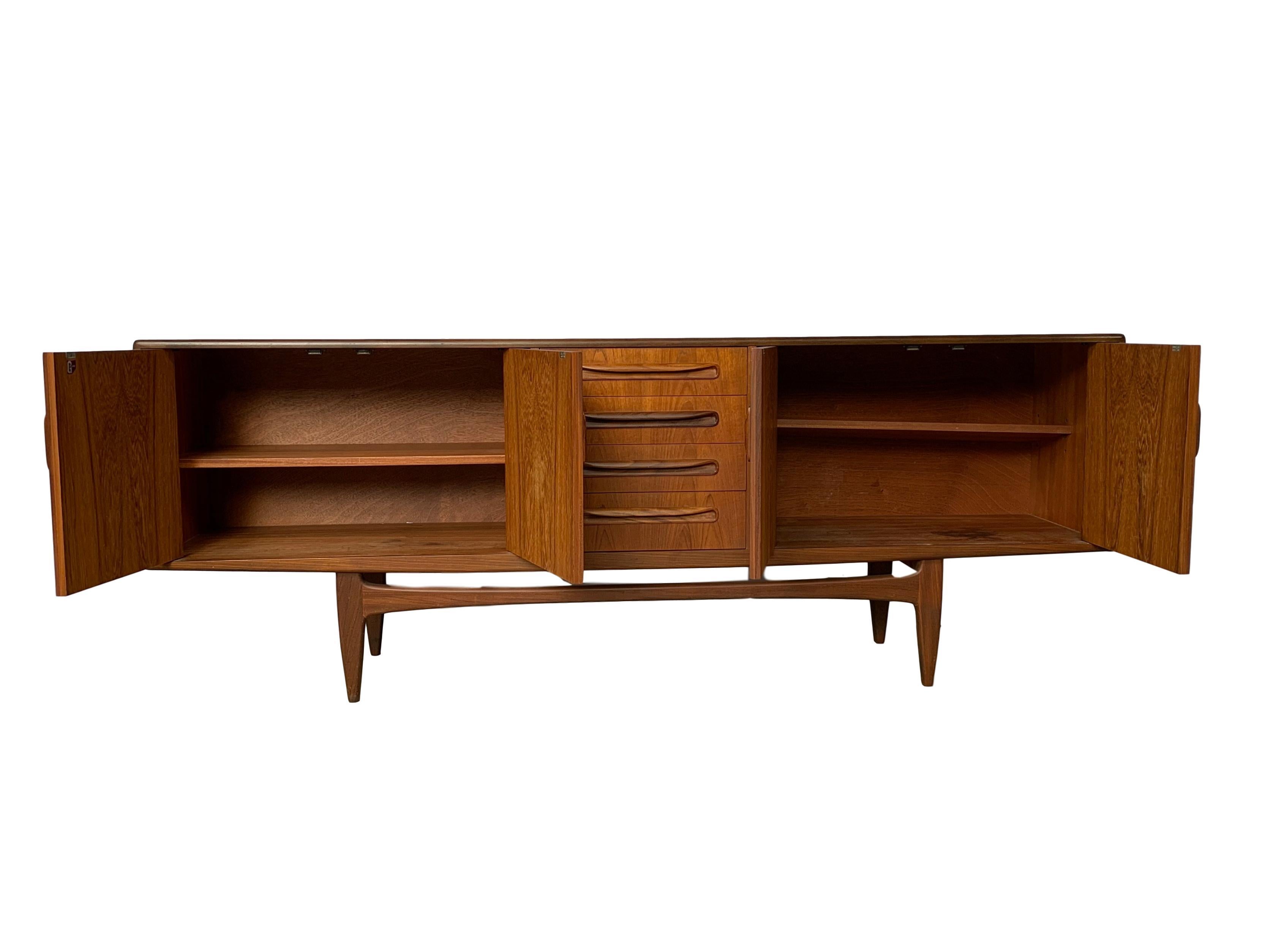 Mid-Century Modern credenza sideboard by G-Plan, circa 1967 in solid teak and afromasia teak on ‘Floating Base,’ with extensively fitted interior. Built to the highest standards, the piece exudes quality, beauty and style. Highly sought after