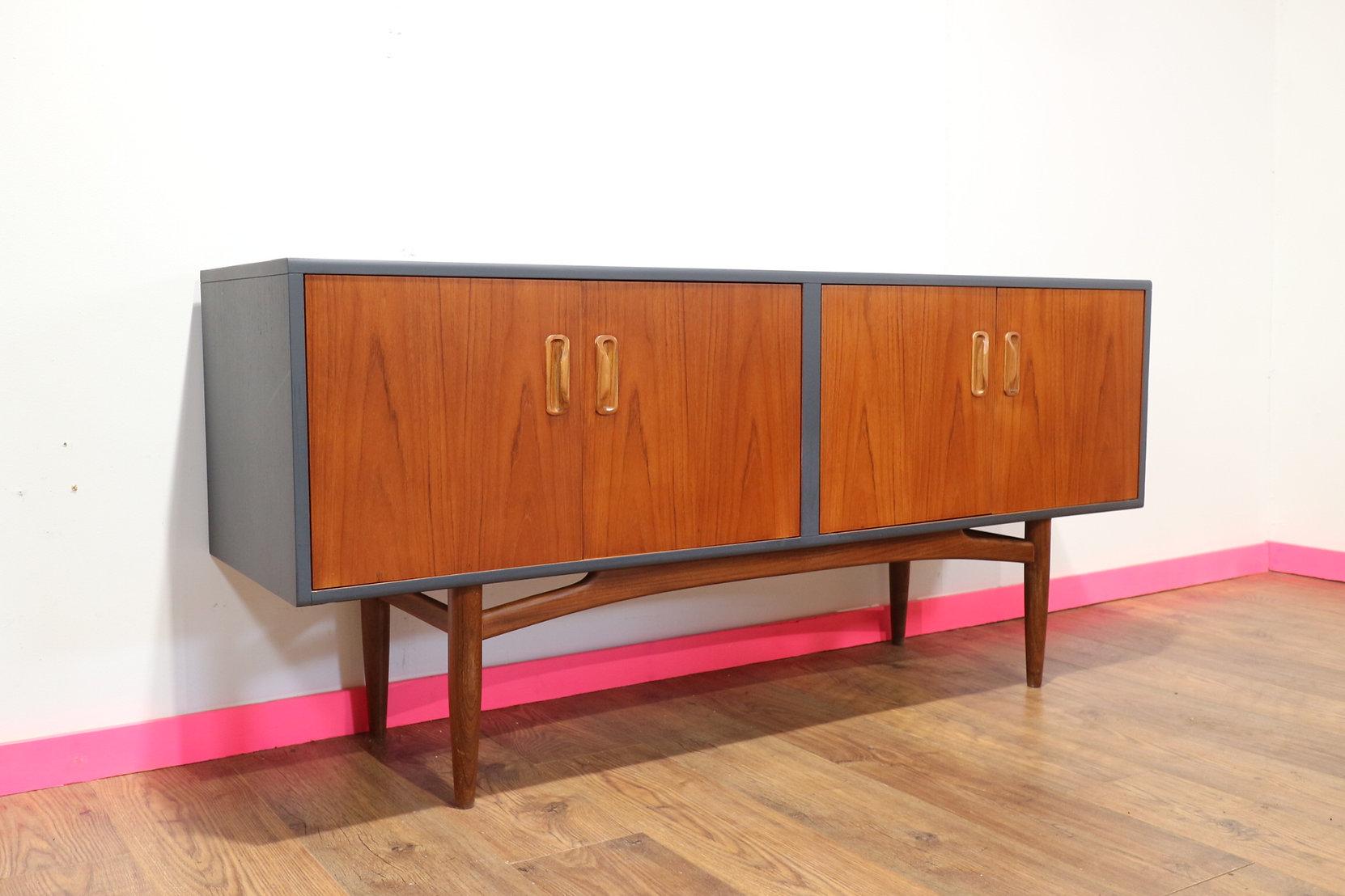 A stunning credenza made by British company G plan as part of their fresco range. This cabinet has been painted grey on the outer case thats contrasts beautifully with the teak doors and legs. A fantastic piece of furniture and great for