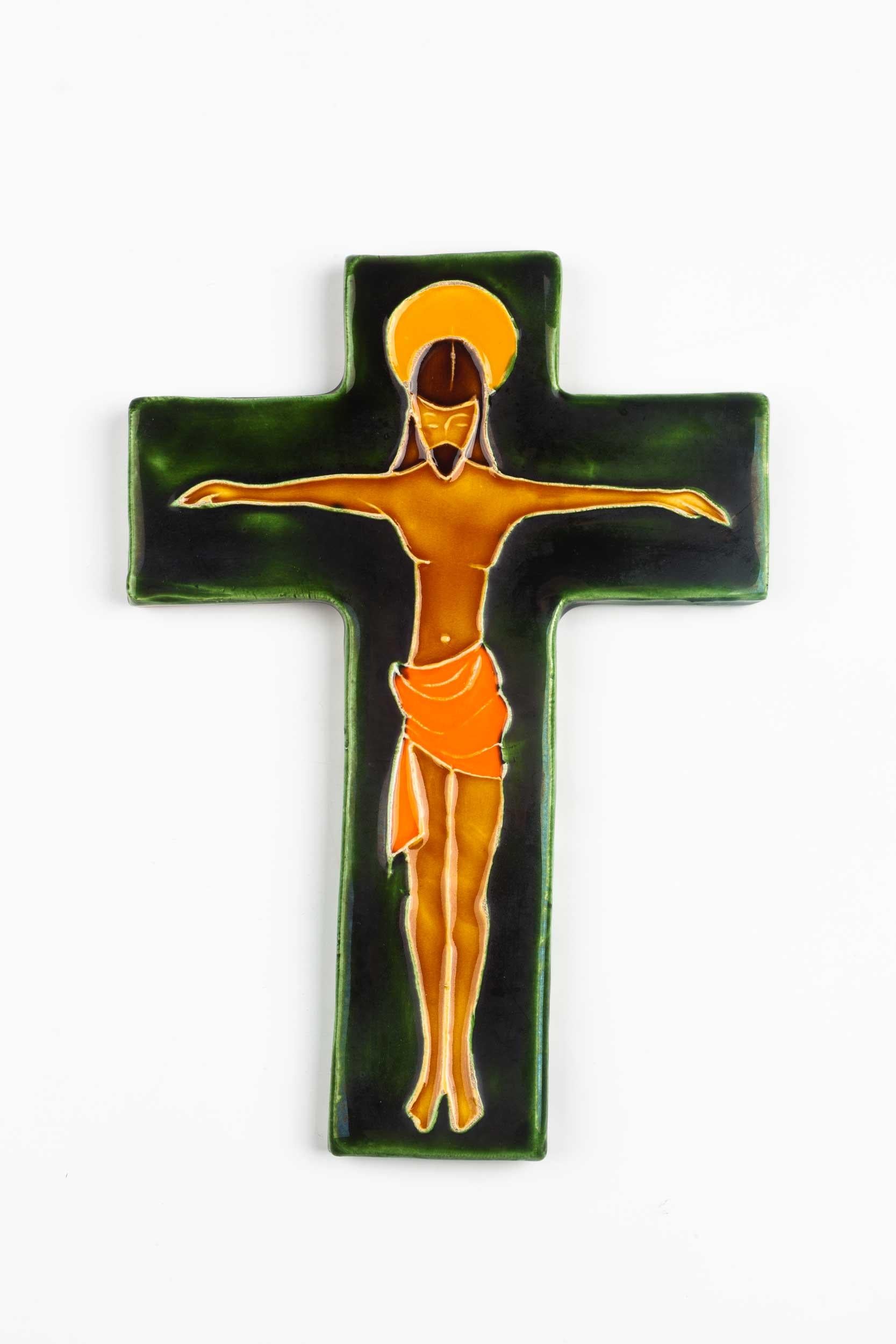 Brillante Tiefe der Farben in diesem handbemalten grünen, gelben und orangefarbenen europäischen Wandkreuz aus der Mitte des Jahrhunderts. Glänzende Glasur über einer subtil voluminösen, mit Linien gezeichneten Christusfigur in anmutiger