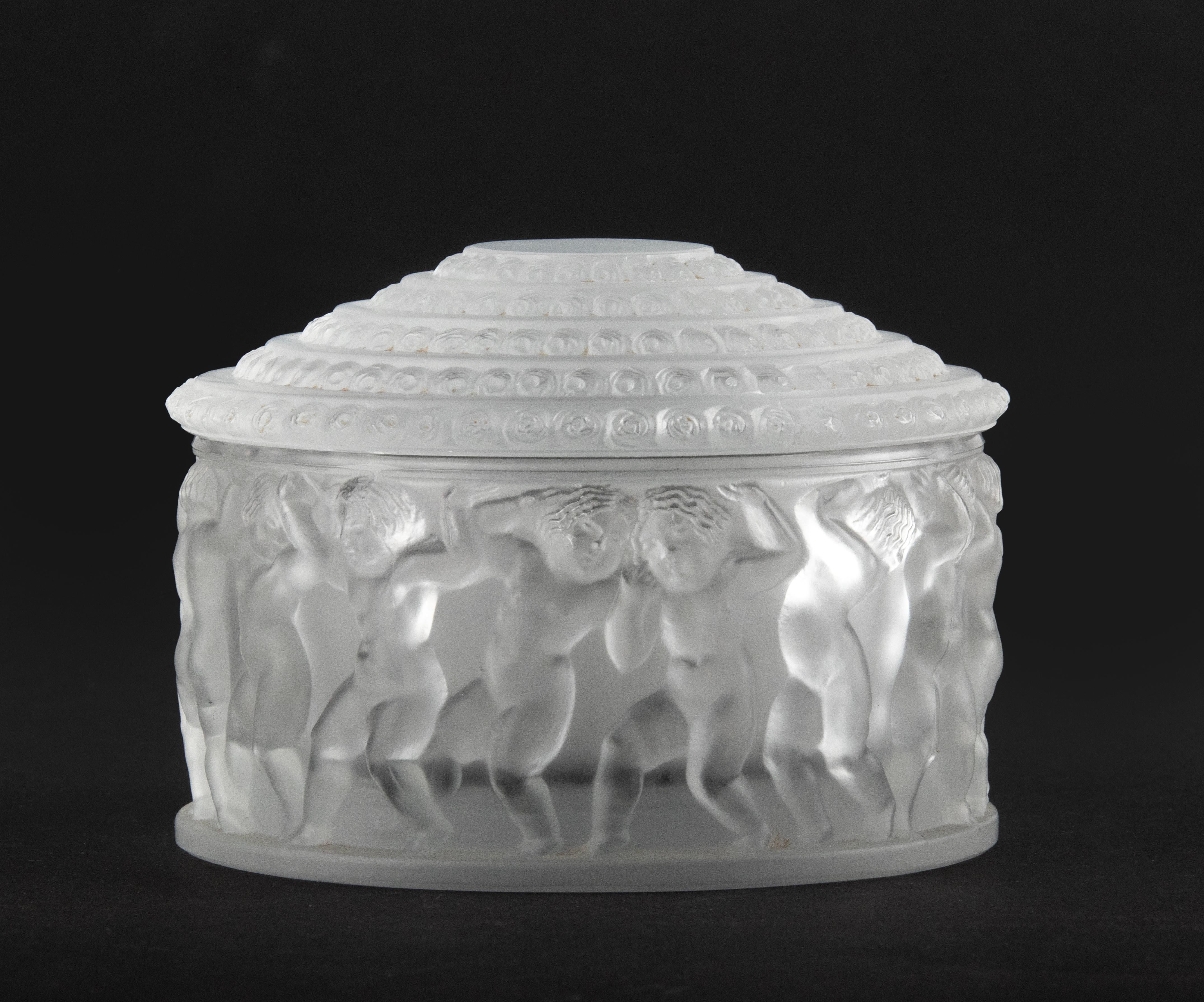 Decorative crystal box made by the French brand Lalique. The box is decorated with dancing children and delicate roses on the lid. Signed on the bottom.
Some scratches on the inside of the lid (not visible from the outside), otherwise the box is in