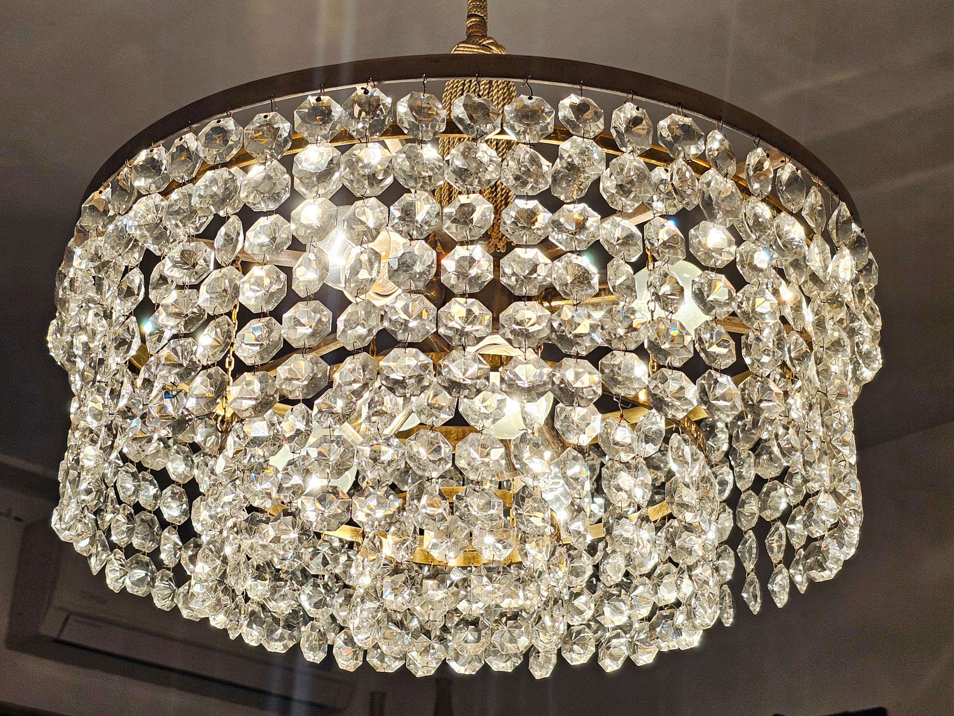 In this listing you will find a gorgeous and very elegant Mid Century Modern chandelier attributed to a renowned maker of luxury lighting based in Vienna - Bakalowits. It features a gold plated brass fixture with 3 tiers of hand polished crystals,