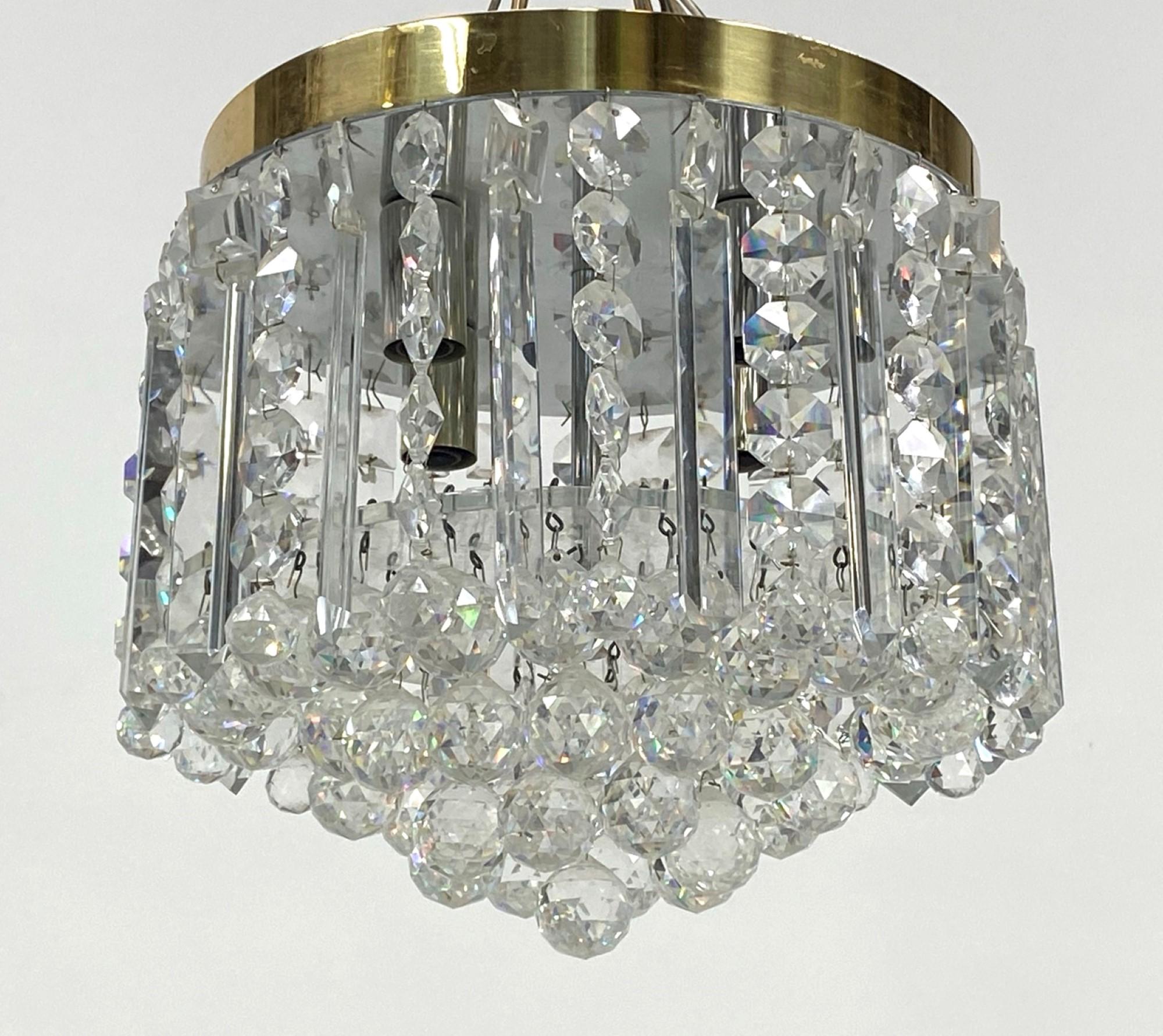 Mid-Century Modern flush mount crystal chandelier with polished brass ceiling mounted lighting pan. These were part of the original décor of a mansion in Beverly Hills. Features long crystals and a faceted ball crystal. Priced each. This can be seen