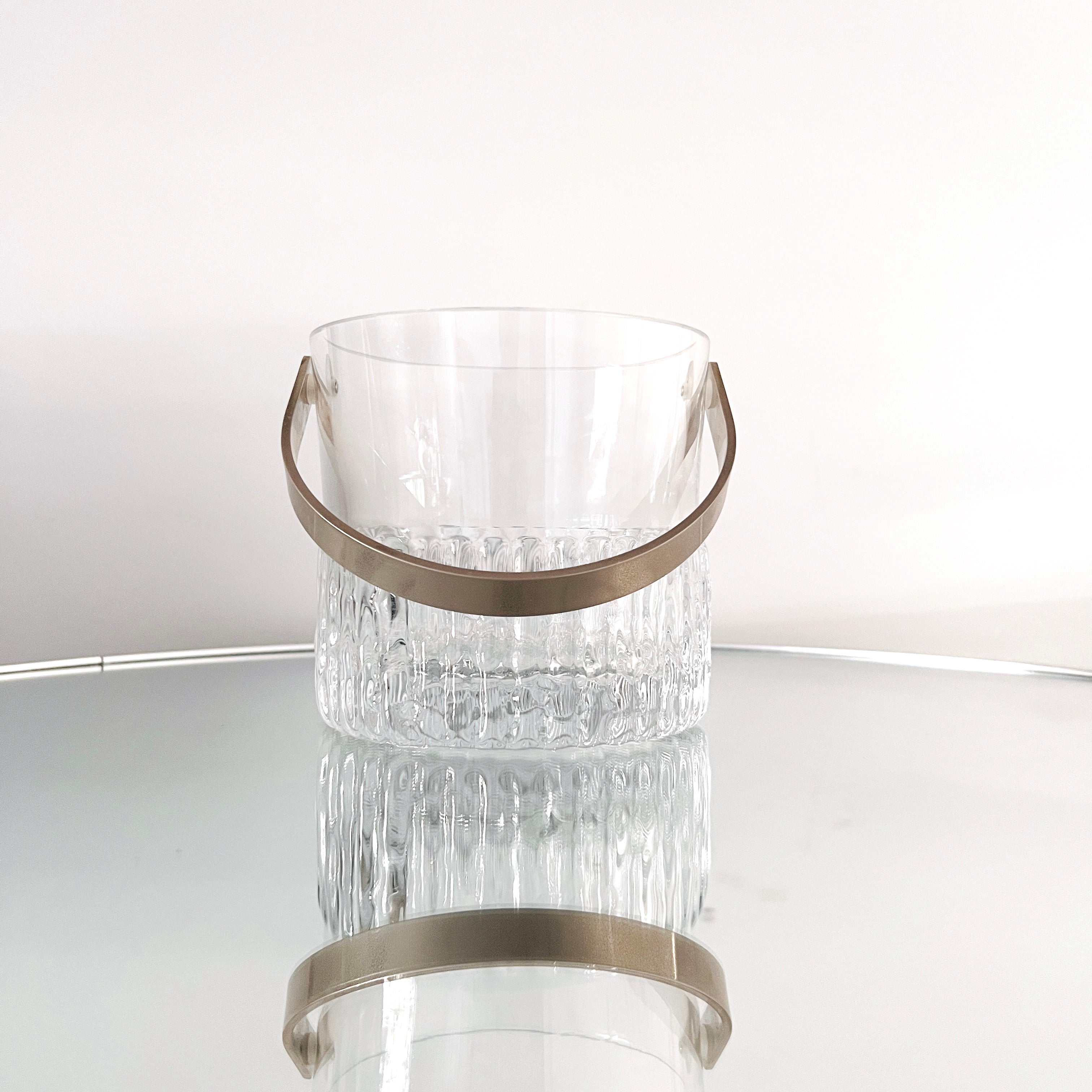 Heavyweight handcrafted crystal ice bucket with fluted and textured design resembling ice glass or icicles. The personal sized ice bucket features polished edges and a stainless steel handle. Makes a chic addition to any barware set and can double