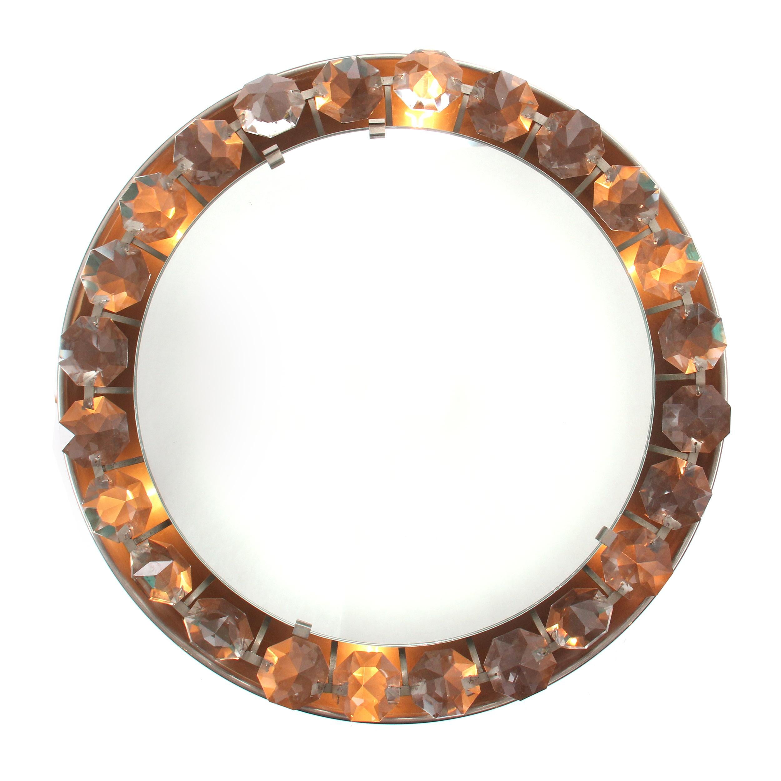 A Mid-Century Modern wall mount mirror framed by a row of large back lit crystals. Made in the USA, circa 1950s.