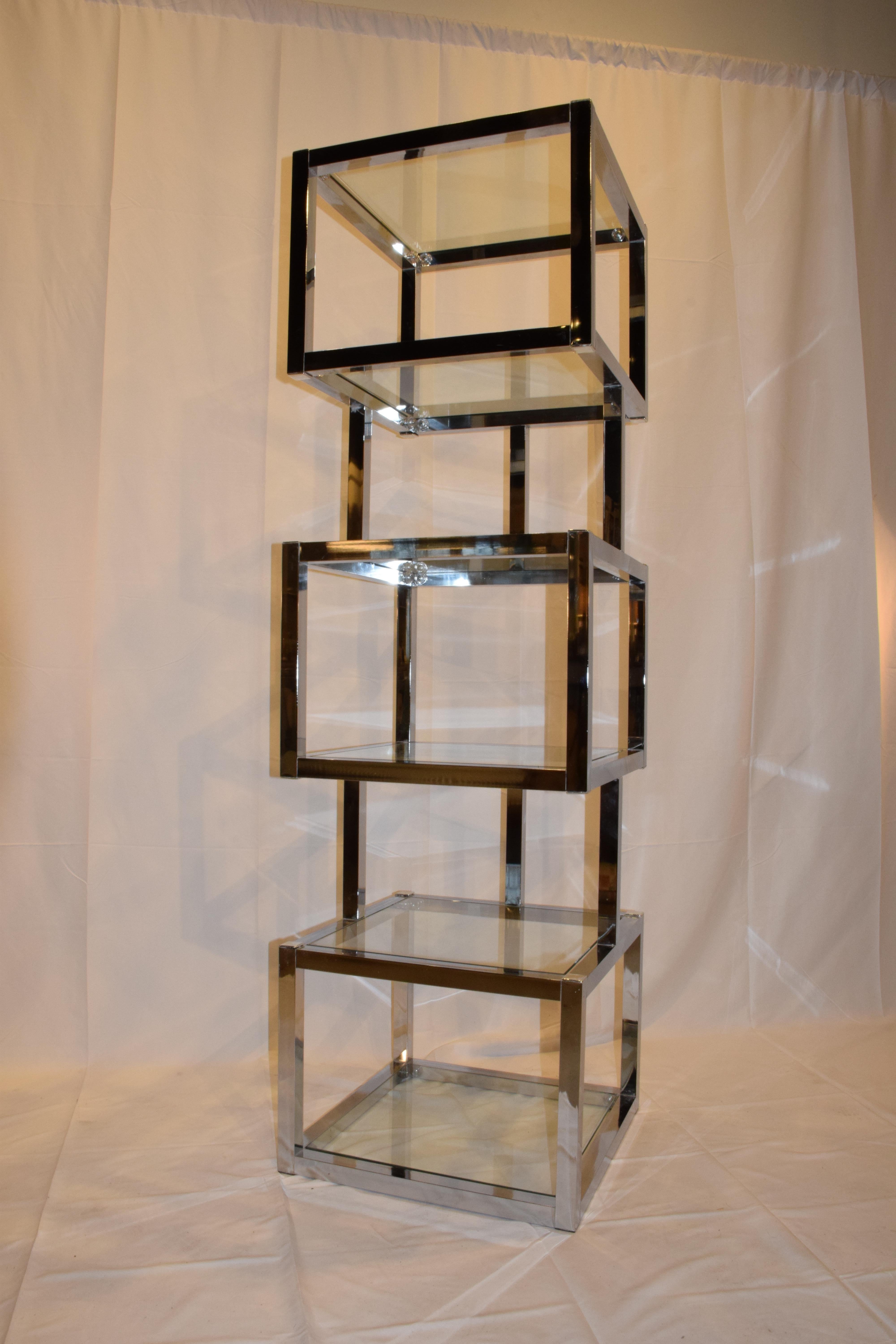 This is a Mid-Century Modern cube chrome and glass étagère. The étagère features cube shaped display units with six glass shelves which includes glass on the top. This is a wonderful piece to display your treasures or books adding sleek modern