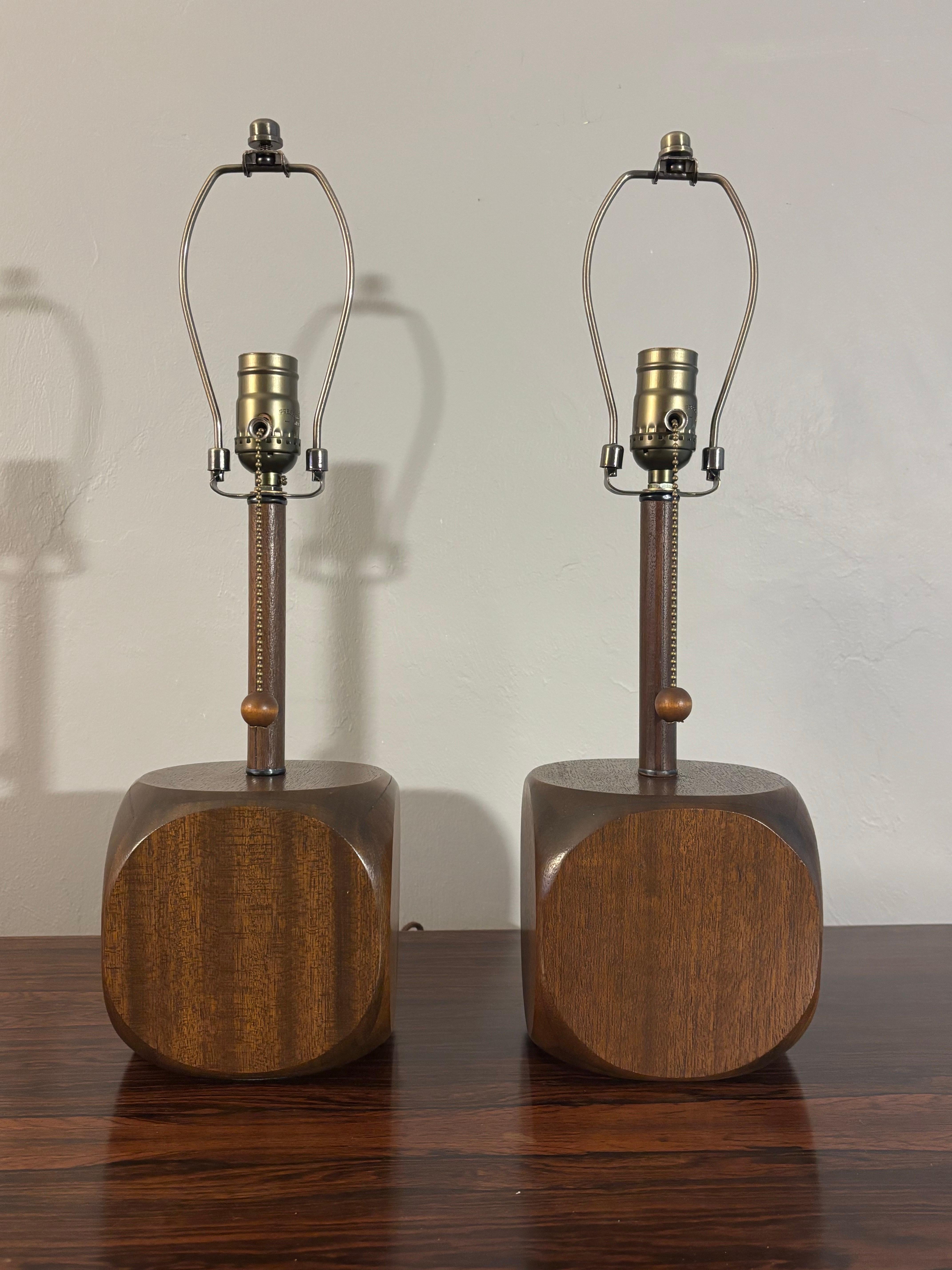 Excepcional y única pareja de lámparas de sobremesa de mediados de siglo. Cubos de lo que creemos que es madera de nogal redondeados con un tallo chapado hasta el bulbo. Las lámparas tienen una cuerda de tracción con una bola de madera en el extremo