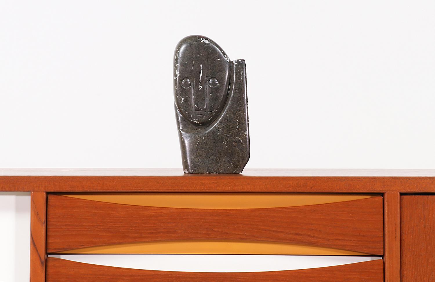 Fascinating Mid-Century Modern carved stone cubist sculpture designed and manufactured in the United States, circa 1970s. This fascinating cubist face sculpture features an expertly carved patinated stone body with clear lines and showing wear from